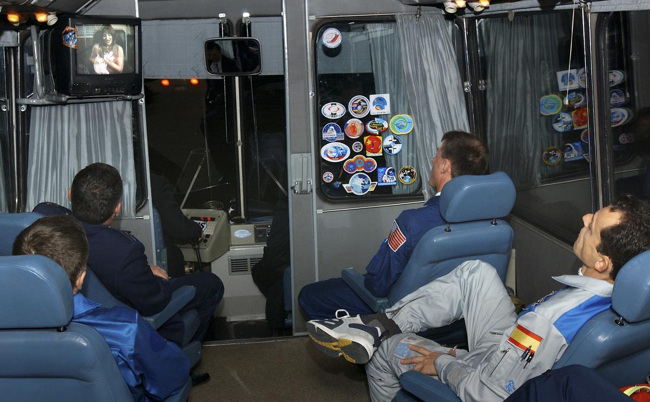 Expedition 8 Soyuz Commander Alexander Kaleri, clockwise from lower left, Gen. Valery Korzun, the Chief of the Cosmonaut Corps, Commander and NASA Science Officer Michael Foale and European Space Agency astronaut Pedro Duque of Spain watch home videos aboard the bus transporting the crew to the launch pad at the Baikonur Cosmodrome in Kazakhstan, Saturday, Oct. 18, 2003, prior to the crew's launch to the Interrnational Space Station. The viewing of home videos on the bus is one of many prelaunch traditions for all departing crews. Photo Credit (NASA/Bill Ingalls)