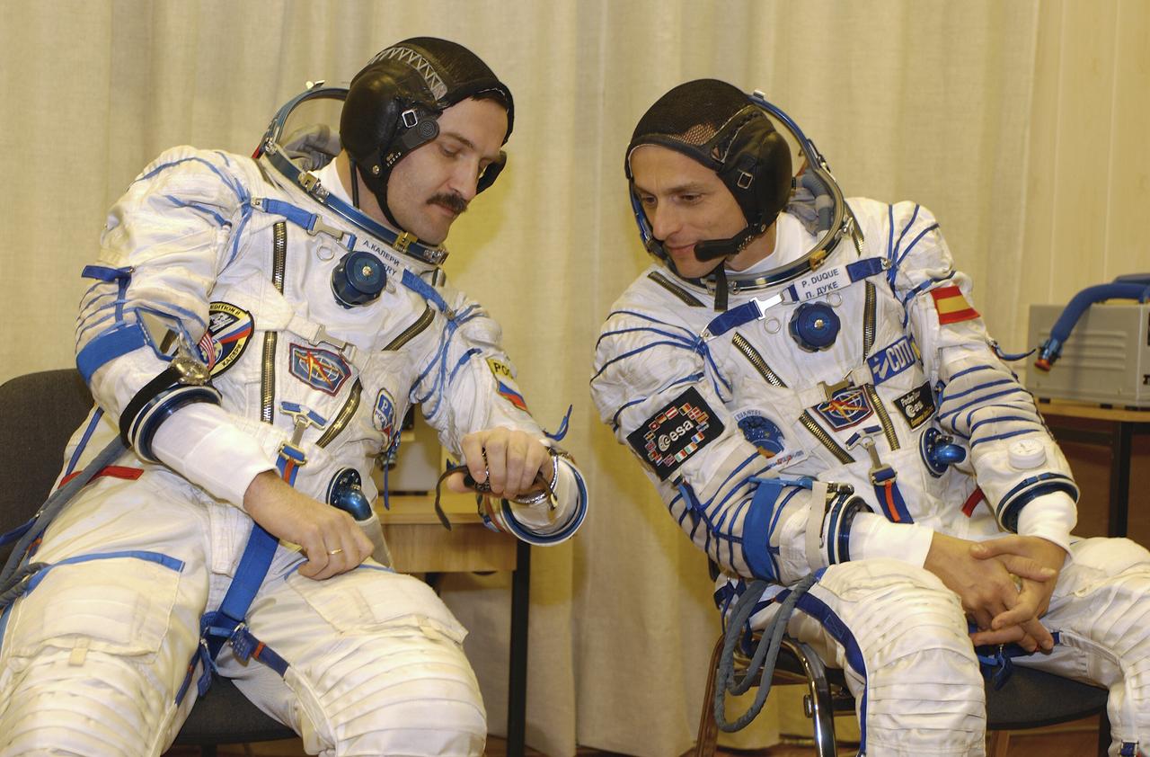 Expedition 8 Soyuz Commander Alexander Kaleri, left and European Space Agency Astronaut Pedro Duque, of Spain, discuss procedures while suiting up, Saturday, Oct. 18, 2003, prior to departure for the launch pad at the Baikonur Cosmodrome in Kazakhstan. Expedition 8 Commander and NASA Science Officer Mike Foale, Kaleri and Duque were launched on a Soyuz TMA-3 vehicle to the International Space Station, arriving on Oct. 20. Photo Credit (NASA/Bill Ingalls)