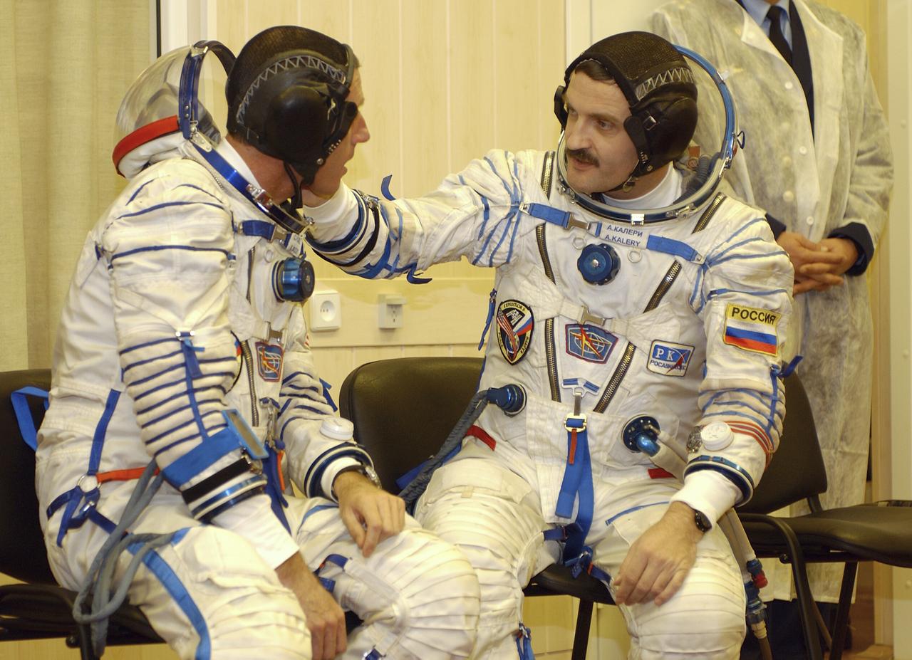 Expedition 8 Commander and NASA Science Officer Michael Foale, left and Expedition 8 Soyuz Commander Alexander Kaleri share a moment while suiting up prior to departing for the launch pad with European Space Agency astronaut Pedro Duque of Spain, Saturday, Oct. 8, 2003, at the Baikonur Cosmodrome in Kazakhstan. The trio were launched on a Soyuz TMA-3 vehicle to the International Space Station, arriving on Oct. 20. Photo Credit (NASA/Bill Ingalls)
