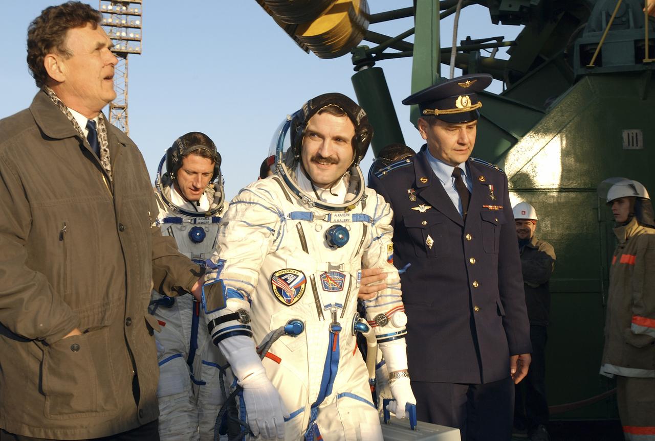 Expedition 8 Soyuz Commander Alexander Kaleri, foreground and Expedition 8 Commander and NASA Science Officer Michael Foale along with European Space Agency astronaut Pedro Duque, not pictured, are escorted to the base of the Soyuz rocket at the Baikonur Cosmodrome in Kazakhstan, Saturday, Oct. 18, 2003. The trio were launched on the Soyuz TMA-3 vehicle to the International Space Station, arriving on Oct. 20. Photo Credit (NASA/Bill Ingalls)