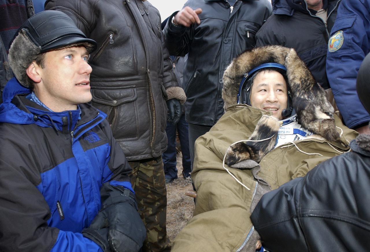 Astronaut Edward T. Lu, Expedition 7 NASA International Space Station Science Officer and Flight Engineer, rests in a chair after landing in the Soyuz TMA-2 spacecraft in Kazakhstan on Monday, October 27, 2003 at 9:41 p.m. (EST).  On the left is NASA Flight Surgeon Dr. Thomas H. Marshburn. Photo Credit: (NASA/Bill Ingalls)