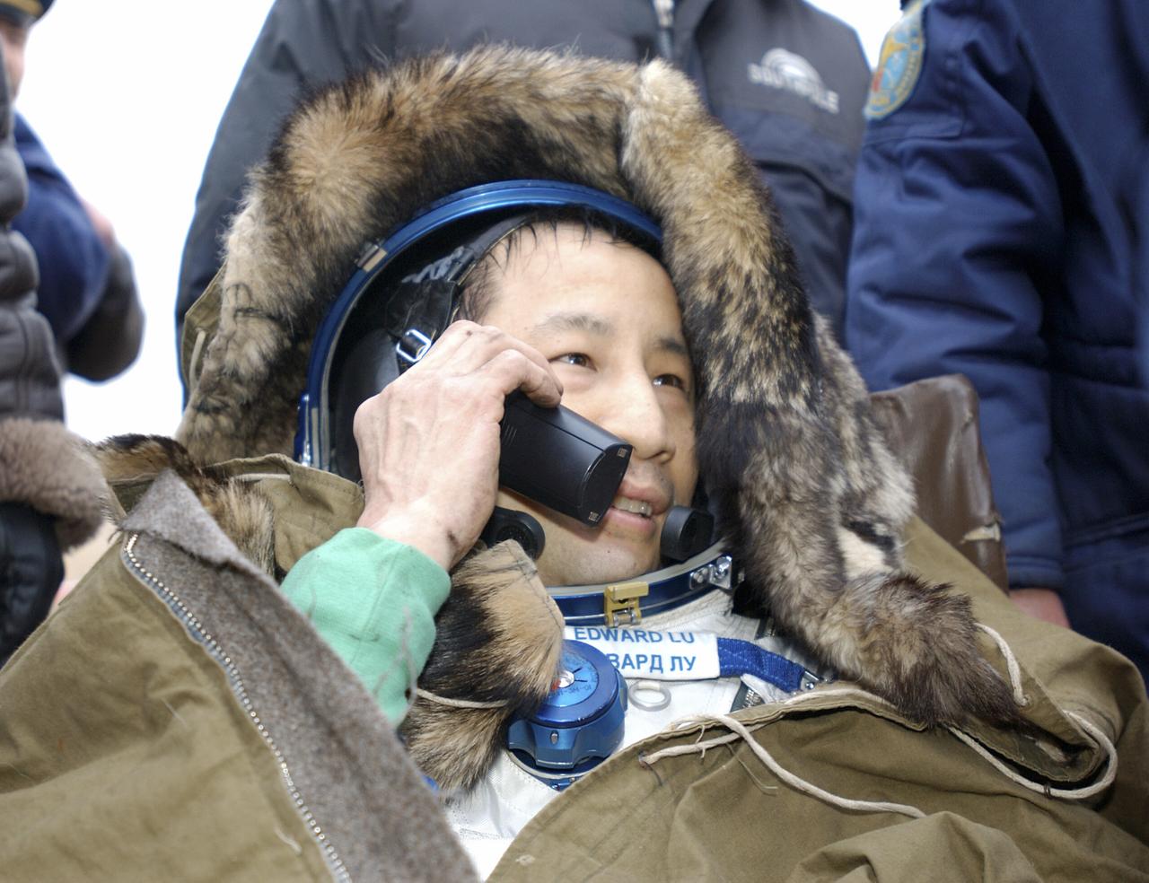 Astronaut Edward T. Lu, Expedition 7 NASA International Space Station Science Officer and Flight Engineer, talks on the telephone after landing in the Soyuz TMA-2 spacecraft in Kazakhstan on Monday, October 27, 2003 at 9:41 p.m. (EST). Photo Credit: (NASA/Bill Ingalls)