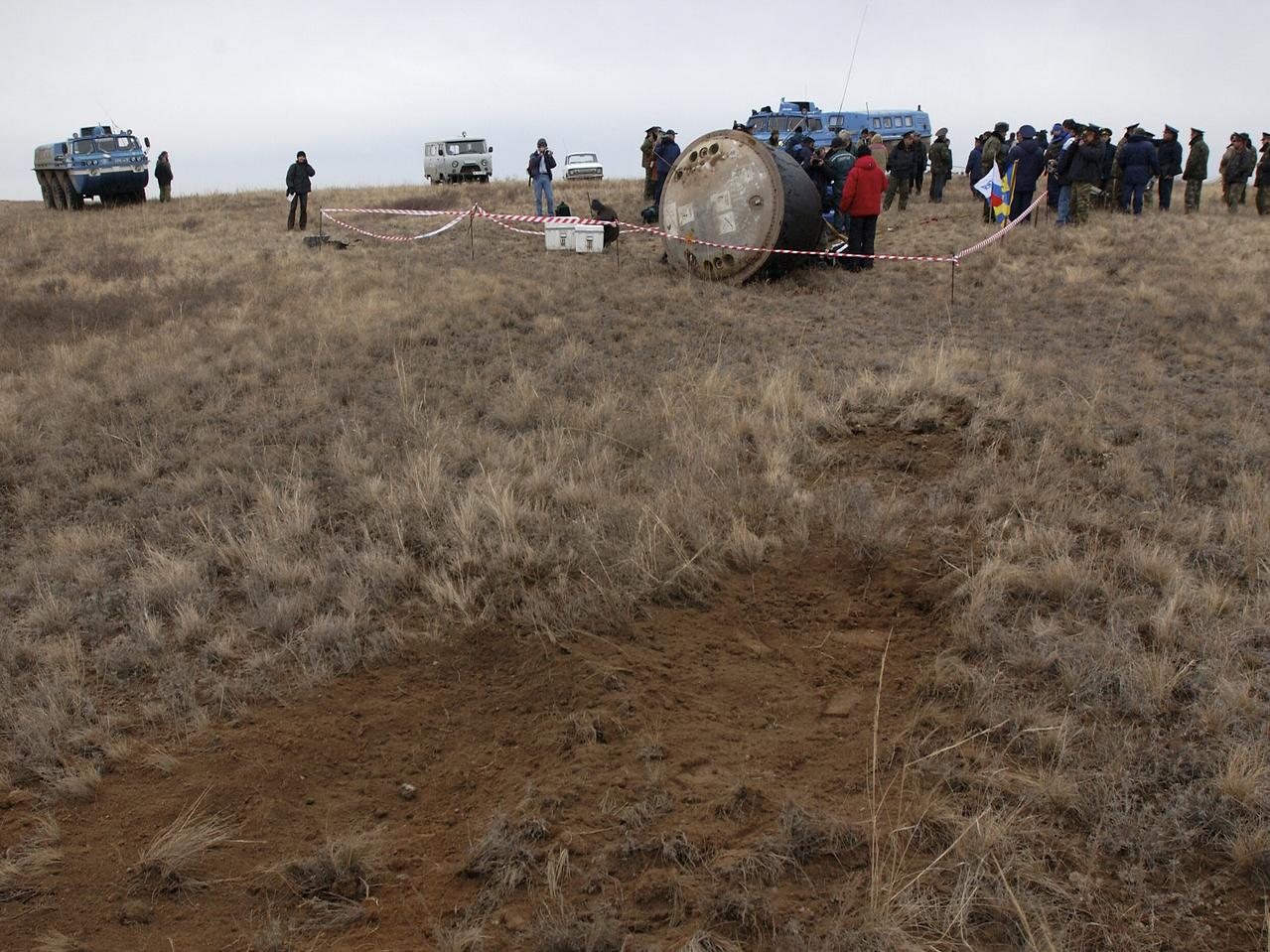 The Soyuz TMA-2 spacecraft carrying cosmonaut Yuri I. Malenchenko, Expedition 7 Mission Commander; astronaut Edward T. Lu, NASA International Space Station Science Officer and Flight Engineer; and European Space Agency (ESA) astronaut Pedro Duque of Spain is photographed on the ground after landing in Kazakhstan on Monday, October 27, 2003 at 9:41 p.m. (EST). The exposed dirt from the landing rockets of the Soyuz is visible in the foreground. Photo Credit: (NASA/Bill Ingalls)