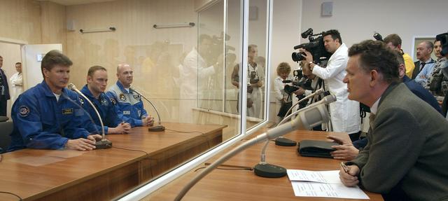 Expedition 9 Commander Gennady Padalka, far left, NASA International Space Station Science Officer Mike Fincke and Flight Engineer and European Space Agency astronaut Andre Kuipers of the Netherlands, far right, speak to members of the State Commission from behind glass at building 254 at the Baikonur Cosmodrome prior to their final fit check in the Soyuz, Wednesday, April 14, 2004, in Baikonur, Kazakhstan.  Photo Credit: (NASA/Bill Ingalls)