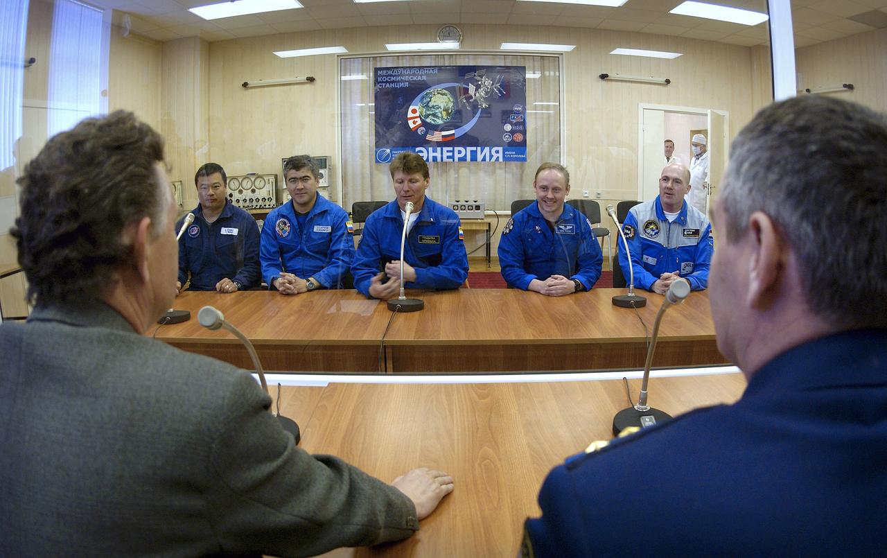 Expedition 9 backup Commander Leroy Chiao, far left, backup Flight Engineer Salizhan Sharipov, second from left, Expedition 9 Commander Gennady Padalka, center, NASA International Space Station Science Officer Mike Fincke, second from right and Flight Engineer and European Space Agency astronaut Andre Kuipers of the Netherlands speak to members of the State Commission from behind glass at building 254 at the Baikonur Cosmodrome prior to their final fit check in the Soyuz, Wednesday, April 14, 2004, in Baikonur, Kazakhstan. Photo Credit: (NASA/Bill Ingalls)
