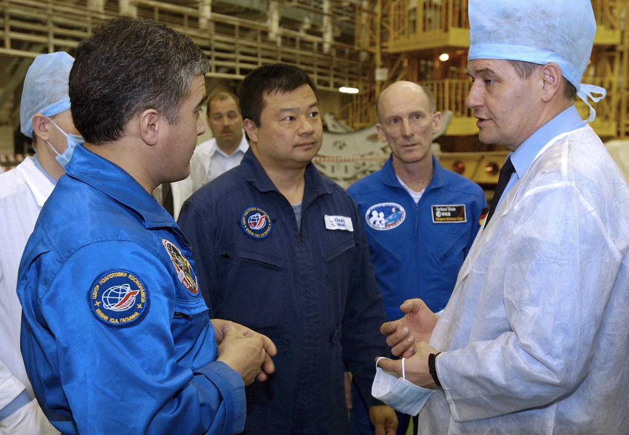 Backup Flight Engineer Salizhan Sharipov, left, Expedition 9 backup Commander Leroy Chiao, center and backup European Space Agency astronaut Gerhard Thiele of Germany talk with Valery Korzun, right, Chief of Cosmonauts, Gagarin Cosmonaut Training Center after the backup crew finished its final fit check in the Soyuz capsule at building 254 at the Baikonur Cosmodrome, Wednesday, April 14, 2004, in Baikonur, Kazakhstan.  Photo Credit: (NASA/Bill Ingalls)
