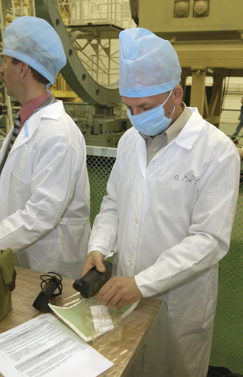 A technician at the Baikonur Cosmodrome packs a satellite phone after instructing the Expedition 9 crew on its use, Wednesday, April, 14, 2004, in Baikonur, Kazakhstan. Photo Credit: (NASA/Bill Ingalls)