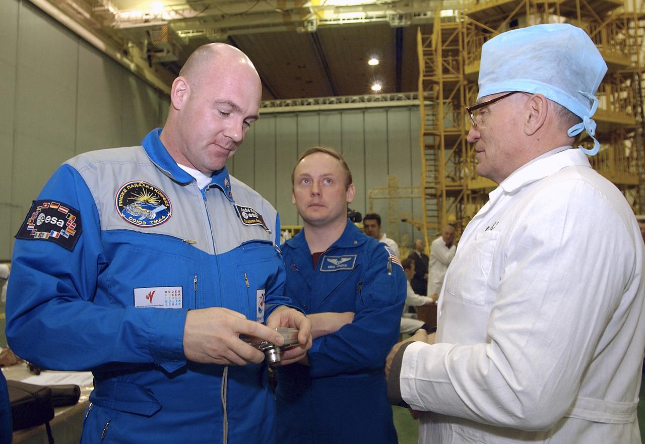Flight Engineer and European Space Agency astronaut Andre Kuipers of the Netherlands, left, and NASA Science Officer Mike Fincke, center, talk with a technician as they prepare to climb the workstand to do their final Soyuz fit check at building 254 at the Baikonur Cosmodrome, Wednesday, April 14, 2004, in Baikonur, Kazakhstan.  Kuipers, who is flying under a commercial contract between ESA and the Russian Federal Space Agency, will return to Earth with the Expedition 8 crew on April 30, 2004.  Photo Credit: (NASA/Bill Ingalls)
