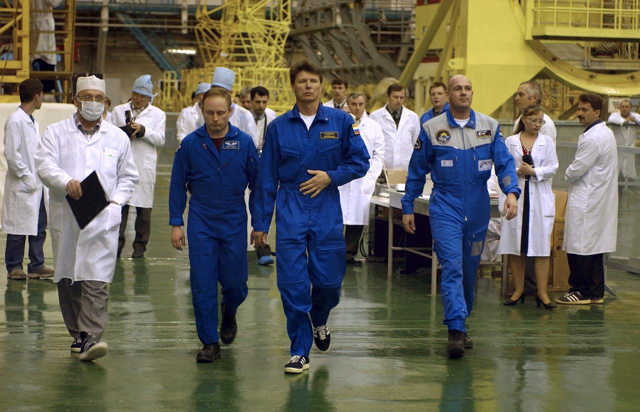 NASA Science Officer Mike Fincke, left, Expedition 9 Commander Gennady Padalka, center and Flight Engineer and European Space Agency astronaut Andre Kuipers of the Netherlands walk from the Soyuz capsule at building 254 at the Baikonur Cosmodrome after their final fit check in the Soyuz, Wednesday, April 14, 2004, in Baikonur, Kazakhstan.  Photo Credit: (NASA/Bill Ingalls)