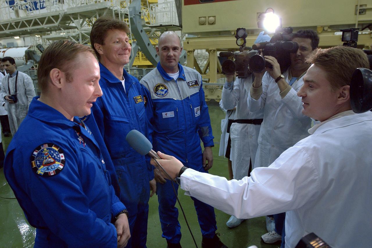 NASA Science Officer Mike Fincke, left, Expedition 9 Commander Gennady Padalka, center and Flight Engineer and European Space Agency astronaut Andre Kuipers of the Netherlands answer questions from reporters after completing their final fit check in the Soyuz capsule at building 254 at the Baikonur Cosmodrome, Wednesday, April 14, 2004, in Baikonur, Kazakhstan.  Photo Credit: (NASA/Bill Ingalls