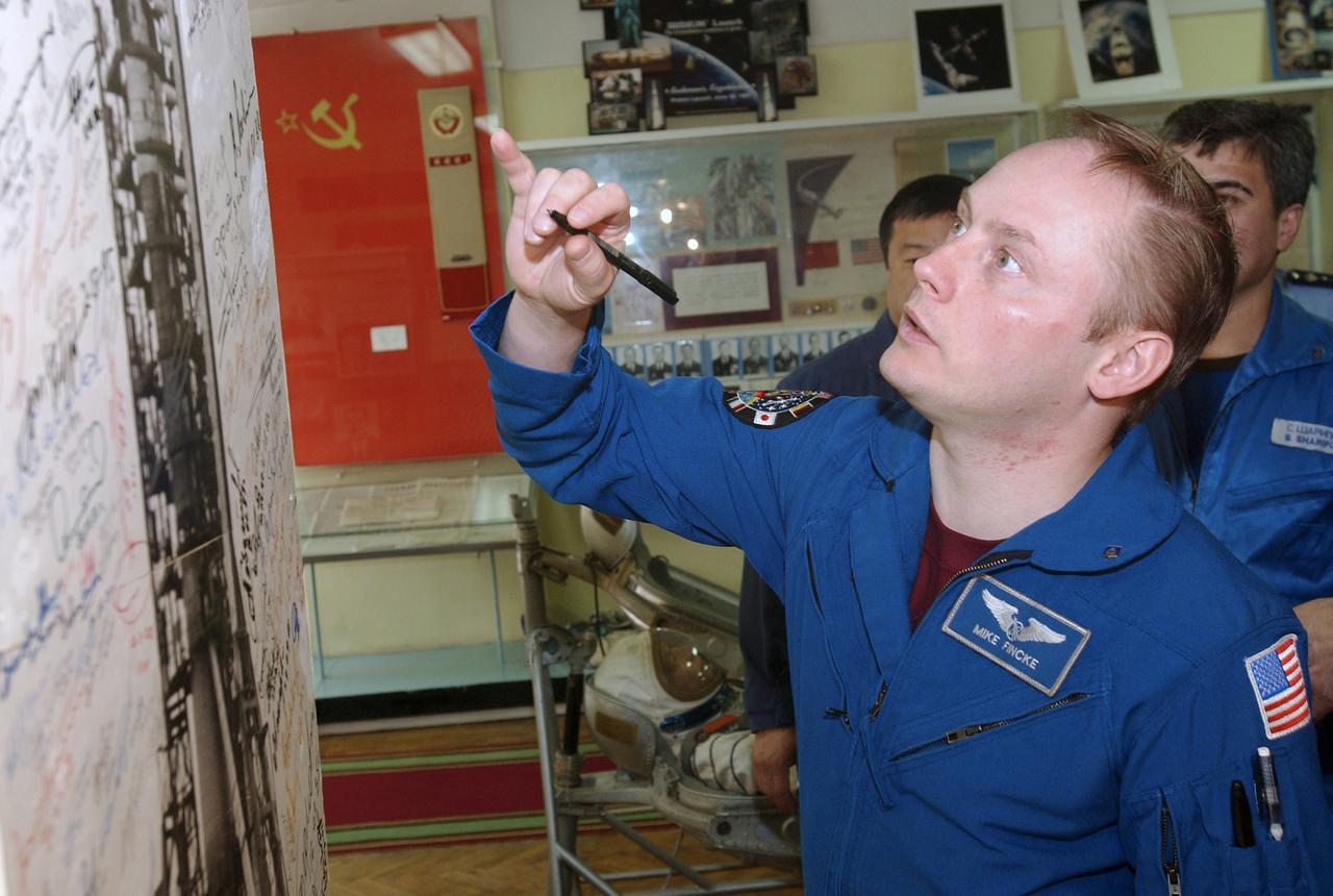 Flight Engineer and NASA Science Officer Mike Fincke prepares to sign a photograph in the space museum located at the Baikonur Cosmodrome, Wednesday, April 14, 2004, in Baikonur, Kazakhstan. Photo Credit: (NASA/Bill Ingalls)