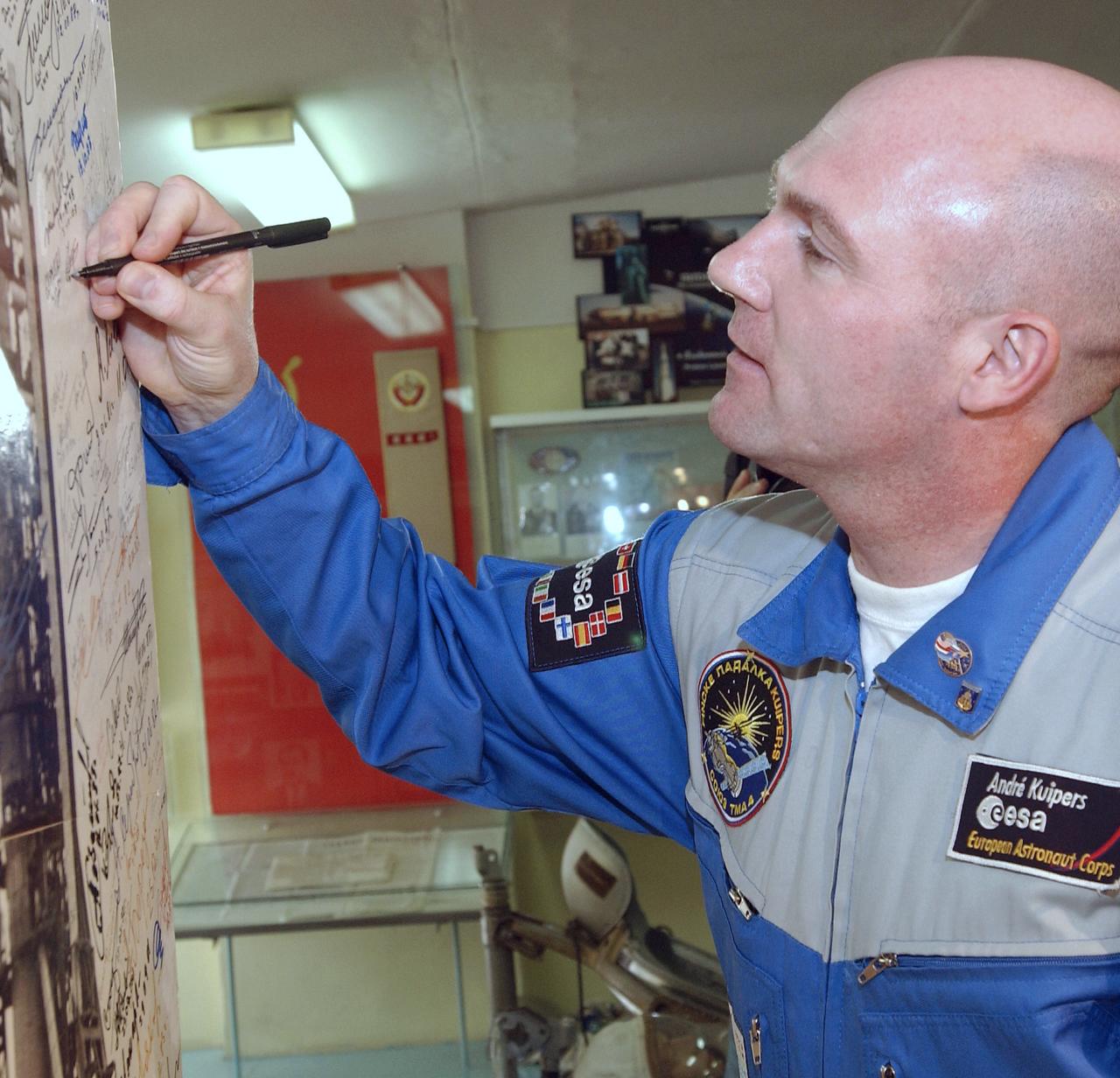 European Space Agency astronaut Andre Kuipers of the Netherlands signs a photograph in the space museum located at the Baikonur Cosmodrome, Wednesday, April 14, 2004, in Baikonur, Kazakhstan. Photo Credit: "NASA/Bill Ingalls"