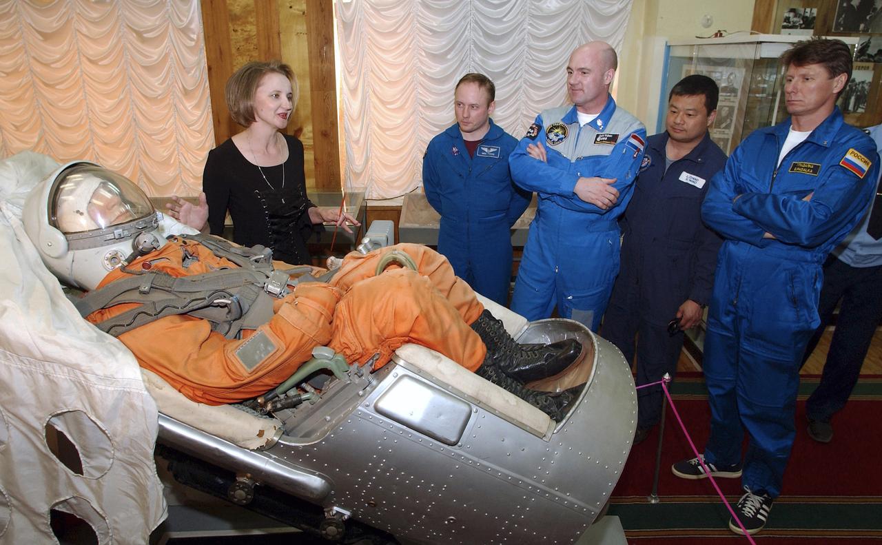 A tour guide at the Baikonur Cosmodrome Space Museum explains the displays to NASA Science Officer Mike Fincke, second from left, Flight Engineer and European Space Agency astronaut Andre Kuipers of the Netherlands, center, backup Expedition 9 Commander Leroy Chiao, second from right and Expedition 9 Commander Gennady Padalka, far right, Wednesday, April 14, 2004, in Baikonur, Kazakhstan. Photo Credit: (NASA/Bill Ingalls)