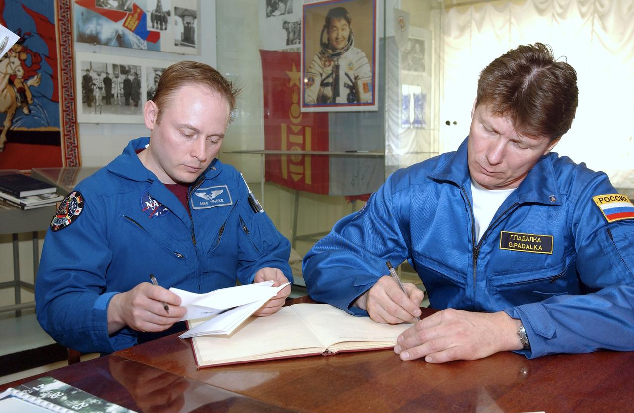 NASA Science Officer Mike Fincke, left and Expedition 9 Commander Gennady Padalka sign books, envelops and mementoes in the space museum located at the Baikonur Cosmodrome, Wednesday, April, 14, 2004, in Baikonur, Kazakhstan. Photo Credit: (NASA/Bill Ingalls)