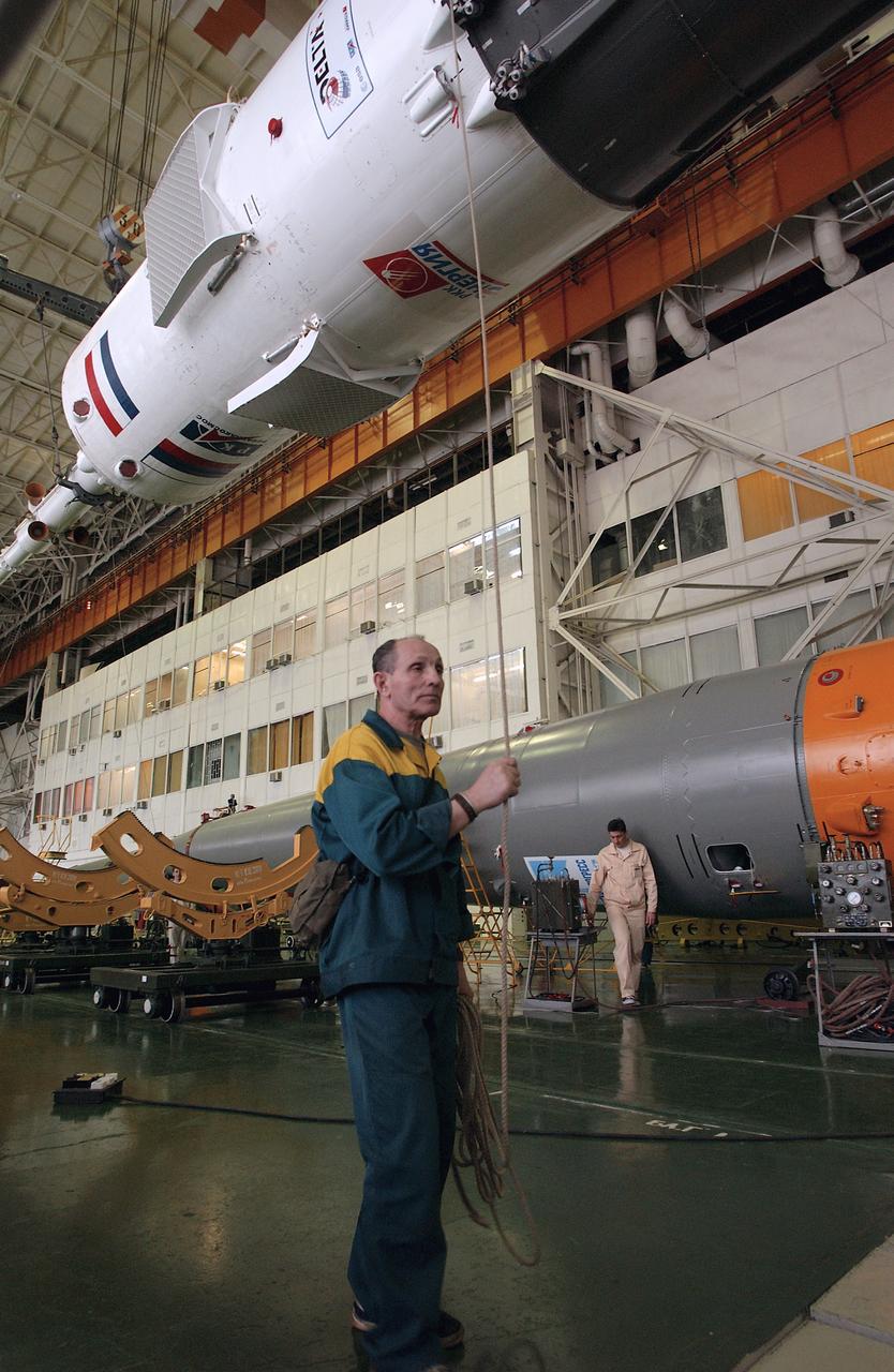 A technician at the Baikonur Cosmodrome walks with the Soyuz capsule as it is prepared to mate with its booster rocket in preparation for the April 19 launch of the Expedition 9 crew and a European astronaut to the International Space Station, Friday, April 16, 2008, in Baikonur, Kazakhstan. Photo Credit: (NASA/Bill Ingalls)