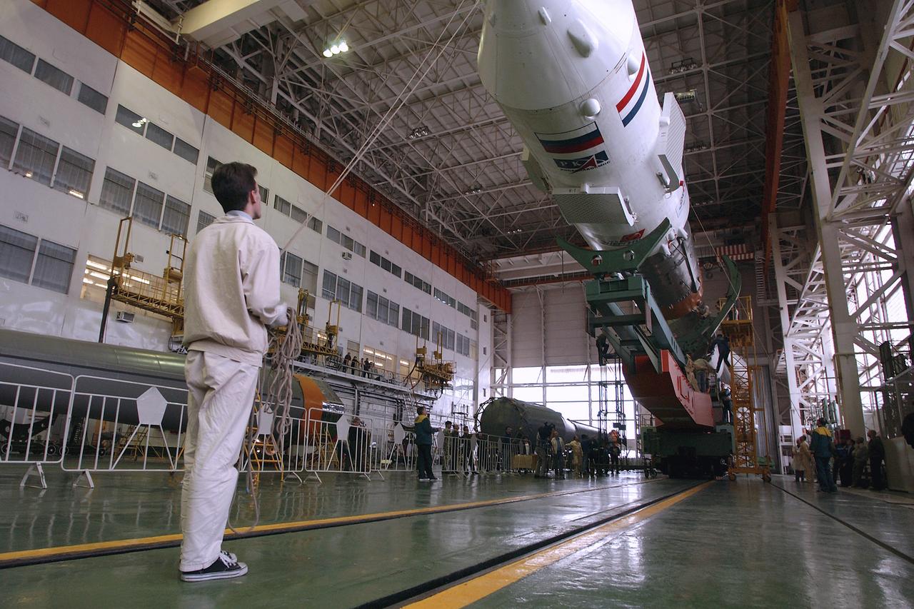 A technician at the Baikonur Cosmodrome walks with the Soyuz capsule as it is prepared to mate with its booster rocket in preparation for the April 19 launch of the Expedition 9 crew and a European astronaut to the International Space Station, Friday, April 16, 2008, in Baikonur, Kazakhstan. Photo Credit: (NASA/Bill Ingalls)