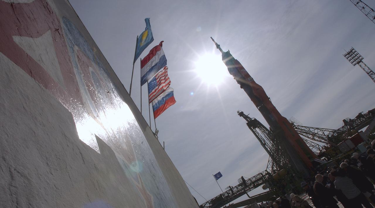 As the flags of Kazakhstan, far left, the Netherlands, second from left, the United States of America and Russia, far right, fly in the stiff breeze, the Soyuz TMA-4 capsule and its booster rocket are raised into position at the launch pad at the Baikonur Cosmodrome on Saturday, April 17, 2004, in Baikonur, Kazakhstan in preparation for the launch of the Expedition 9 crew and a European researcher to the International Space Station on April 19. The Soyuz vehicle is transported to the launch pad horizontally on a railcar from its processing hangar in a process that takes about 2.5 hours to complete. Photo Credit: (NASA/Bill Ingalls)