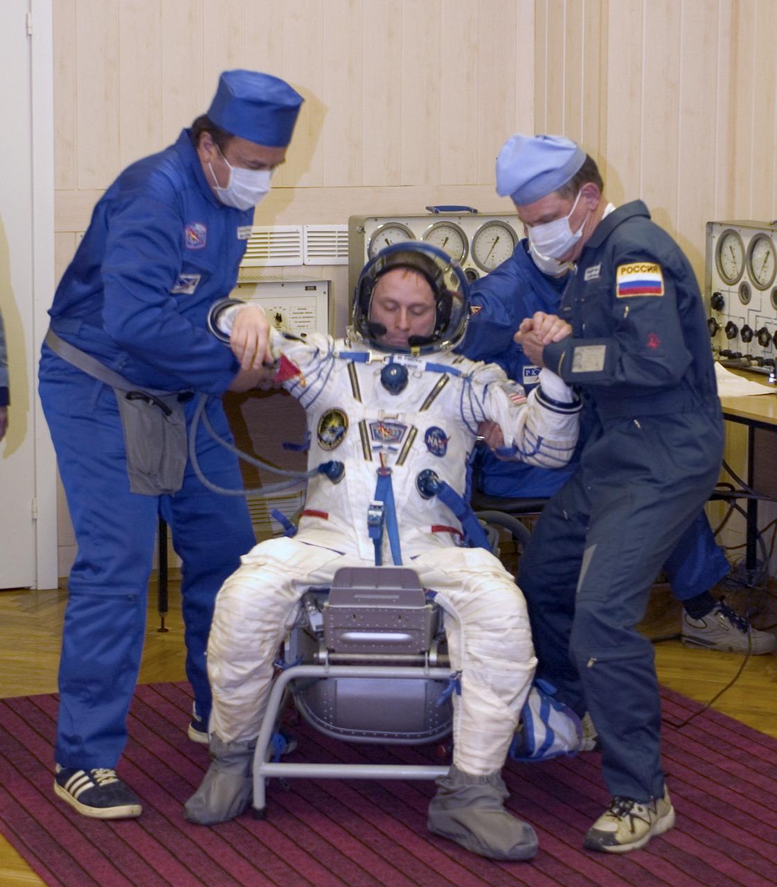 Flight Engineer and NASA Science Officer Mike Fincke is assisted up after having is Russian Sokul suit pressure checked prior to launch, Monday, April 19, 2004, in Baikonur, Kazakhstan. Photo Credit: (NASA/Bill Ingalls)