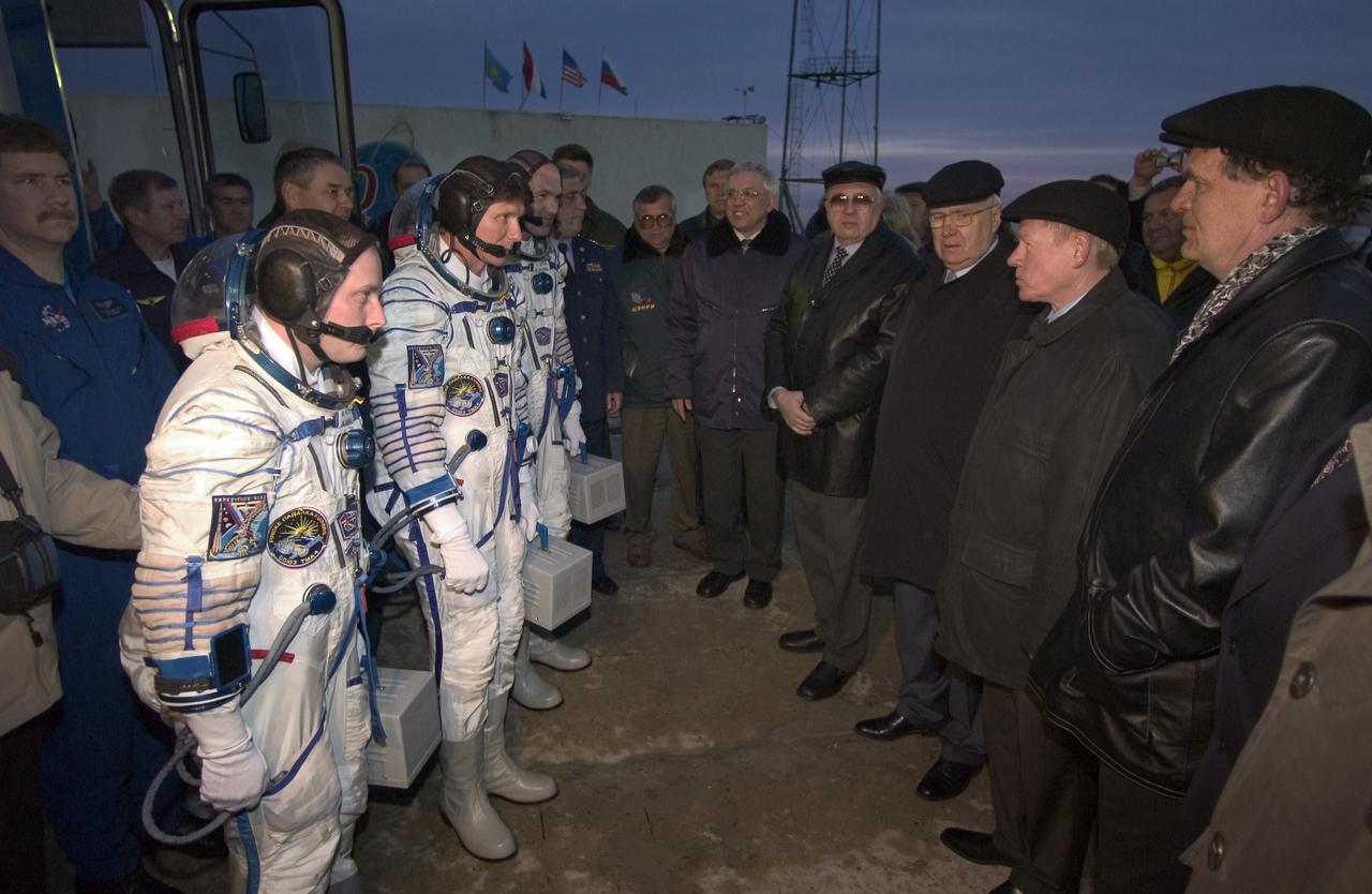 Flight Engineer and NASA Science Officer Mike Fincke, left, Expedition 9 Commander Gennady Padalka, center and European Space Agency astronaut Andre Kuipers of the Netherlands arrive at the Soyuz launch pad prior to being launched to the ISS, and are met by space officials including Anatoly Perminov, Director of the Russian Space Agency, second from far right, Monday, April 19, 2004, in Baikonur, Kazakhstan.  Photo Credit: (NASA/Bill Ingalls)