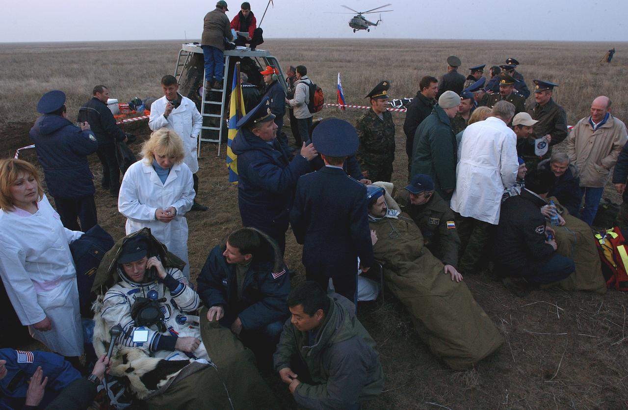Expedition 8 Commander Mike Foale, lower left, Soyuz Flight Engineer Alexander Kaleri and European Space Agency astronaut Andre Kuipers of the Netherlands, partially hidden, are tended to after touching down in north central Kazakhstan, Friday, April 30, 2004. Foale and Kaleri completed 195 days in space aboard the International Space Station, while Kuipers returned after an 11-day research mission as part of a commercial agreement between ESA and the Russian Federal Space Agency. Photo Credit (NASA/Bill Ingalls)