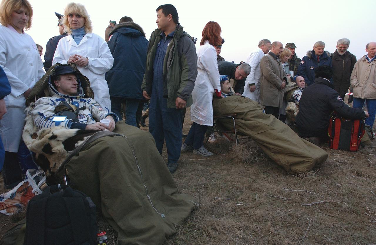 Expedition 8 Commander Michael Foale, left, Soyuz Flight Engineer Alexander Kaleri and European Space Agency astronaut Andre Kuipers, of the Netherlands, right, are seen seated after landing in north central Kazakhstan, Friday, April 30, 2004, in a Soyuz TMA-3 capsule. Foale and Kaleri completed 195 days in space aboard the International Space Station, while Kuipers returned after an 11-day research mission as part of a commercial agreement between ESA and the Russian Federal Space Agency. Photo Credit: (NASA/Bill Ingalls)