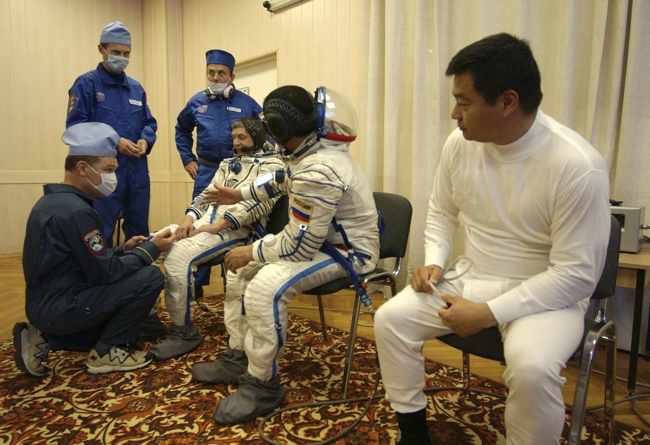 Expedition 10 Commander and NASA Science Officer Leroy Chiao, right, Flight Engineer and Soyuz Commander Salizhan Sharipov and Russian Space Forces cosmonaut Yuri Shargin, left, donned their launch and entry suits and climbed aboard their Soyuz TMA-5 spacecraft Friday, October 5, 2004, at the Baikonur Cosmodrome in Kazakhstan for a dress rehearsal of launch day activities leading to their liftoff October 14 to the International Space Station. Chiao and Sharipov, the first crew of all-Asian extraction, will spend six months on the Station.  Shargin will return to Earth October 24 with the Stations' current residents, Expedition 9 Commander Gennady Padalka and NASA Flight Engineer and Science Officer Mike Fincke.  Photo Credit: (NASA/Bill Ingalls)
