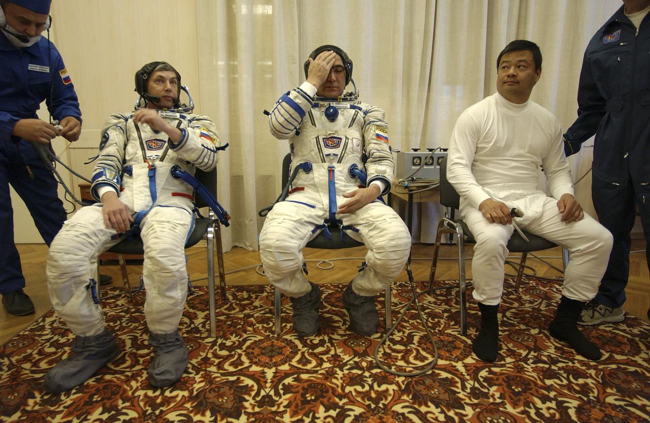 Expedition 10 Commander and NASA Science Officer Leroy Chiao, right, Flight Engineer and Soyuz Commander Salizhan Sharipov and Russian Space Forces cosmonaut Yuri Shargin, left, donned their launch and entry suits and climbed aboard their Soyuz TMA-5 spacecraft Friday, October 5, 2004, at the Baikonur Cosmodrome in Kazakhstan for a dress rehearsal of launch day activities leading to their liftoff October 14 to the International Space Station. Chiao and Sharipov, the first crew of all-Asian extraction, will spend six months on the Station.  Shargin will return to Earth October 24 with the Stations' current residents, Expedition 9 Commander Gennady Padalka and NASA Flight Engineer and Science Officer Mike Fincke.  Photo Credit: (NASA/Bill Ingalls)