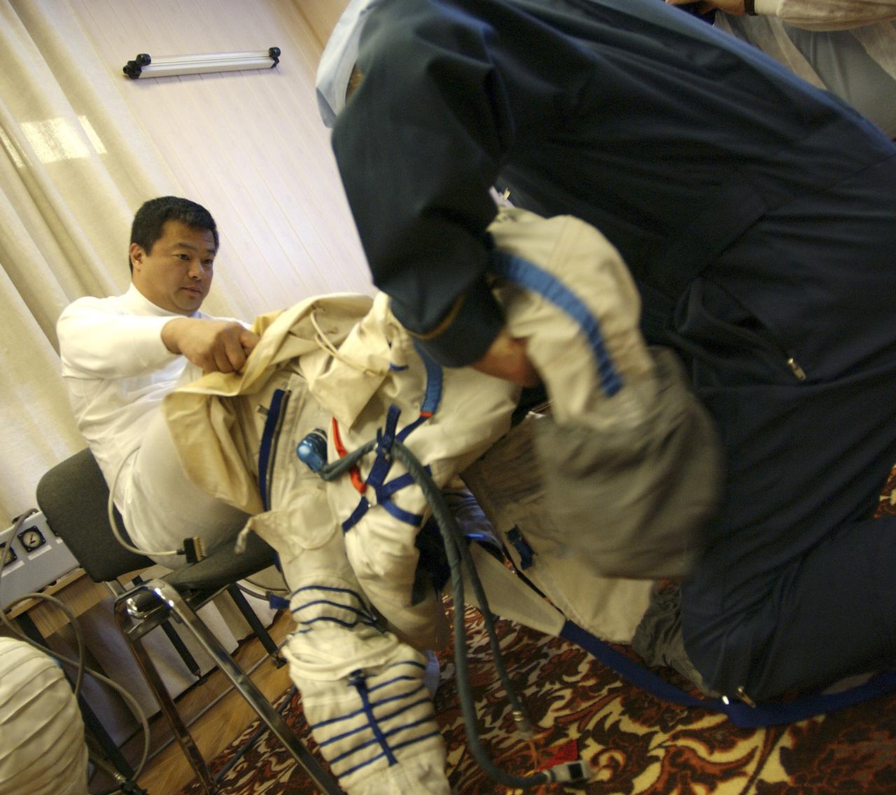 Expedition 10 Commander and NASA Science Officer Leroy Chiao donned his launch and entry suit and climbed aboard the Soyuz TMA-5 spacecraft Friday, October 5, 2004, at the Baikonur Cosmodrome in Kazakhstan for a dress rehearsal of launch day activities leading to their liftoff October 14 to the International Space Station.  Chiao and Sharipov, the first crew of all-Asian extraction, will spend six months on the Station.  Shargin will return to Earth October 24 with the Stations' current residents, Expedition 9 Commander Gennady Padalka and NASA Flight Engineer and Science Officer Mike Fincke.  Photo Credit: (NASA/Bill Ingalls)