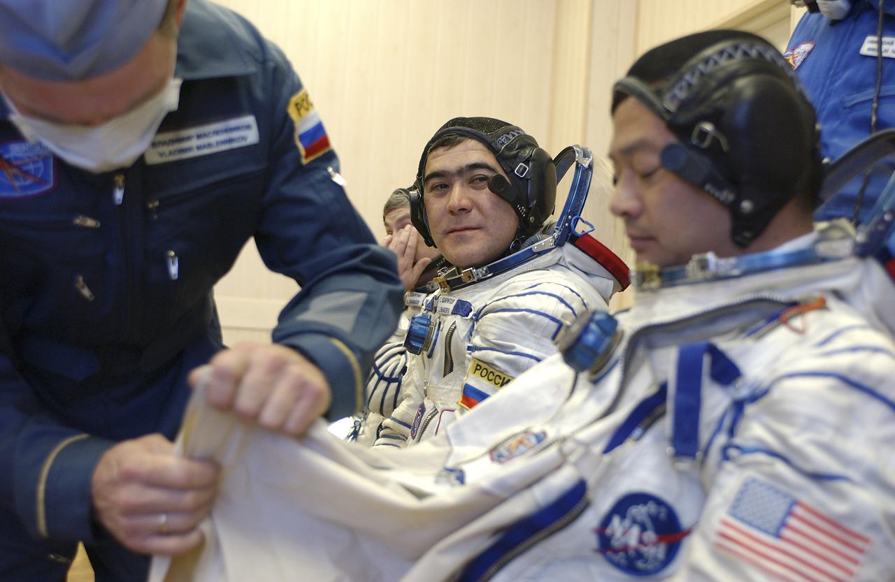 Expedition 10 Commander and NASA Science Officer Leroy Chiao, right, Flight Engineer and Soyuz Commander Salizhan Sharipov and Russian Space Forces cosmonaut Yuri Shargin, left, donned their launch and entry suits and climbed aboard their Soyuz TMA-5 spacecraft Friday, October 5, 2004, at the Baikonur Cosmodrome in Kazakhstan for a dress rehearsal of launch day activities leading to their liftoff October 14 to the International Space Station. Chiao and Sharipov, the first crew of all-Asian extraction, will spend six months on the Station.  Shargin will return to Earth October 24 with the Stations' current residents, Expedition 9 Commander Gennady Padalka and NASA Flight Engineer and Science Officer Mike Fincke.  Photo Credit: (NASA/Bill Ingalls)