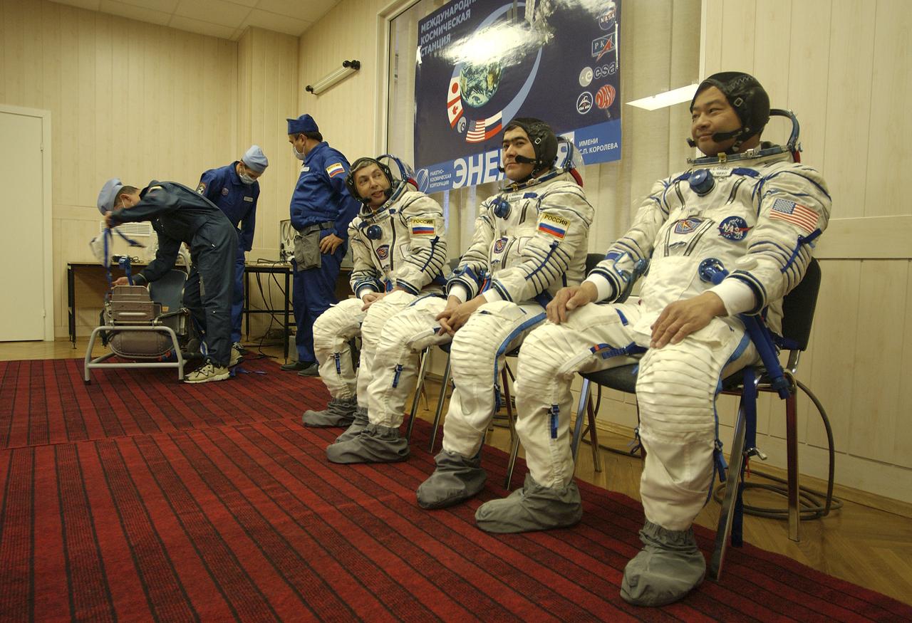 Expedition 10 Commander and NASA Science Officer Leroy Chiao, right, Flight Engineer and Soyuz Commander Salizhan Sharipov and Russian Space Forces cosmonaut Yuri Shargin, left, donned their launch and entry suits and climbed aboard their Soyuz TMA-5 spacecraft Friday, October 5, 2004, at the Baikonur Cosmodrome in Kazakhstan for a dress rehearsal of launch day activities leading to their liftoff October 14 to the International Space Station. Chiao and Sharipov, the first crew of all-Asian extraction, will spend six months on the Station.  Shargin will return to Earth October 24 with the Stations' current residents, Expedition 9 Commander Gennady Padalka and NASA Flight Engineer and Science Officer Mike Fincke.  Photo Credit: (NASA/Bill Ingalls)