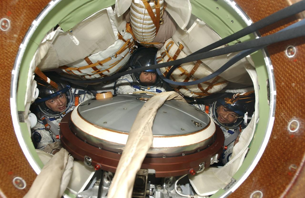 Expedition 10 Commander and NASA Science Officer Leroy Chiao, right, Flight Engineer and Soyuz Commander Salizhan Sharipov and Russian Space Forces cosmonaut Yuri Shargin, left, donned their launch and entry suits and climbed aboard their Soyuz TMA-5 spacecraft Friday, October 5, 2004, at the Baikonur Cosmodrome in Kazakhstan for a dress rehearsal of launch day activities leading to their liftoff October 14 to the International Space Station. Chiao and Sharipov, the first crew of all-Asian extraction, will spend six months on the Station.  Shargin will return to Earth October 24 with the Stations' current residents, Expedition 9 Commander Gennady Padalka and NASA Flight Engineer and Science Officer Mike Fincke.  Photo Credit: (NASA/Bill Ingalls) 