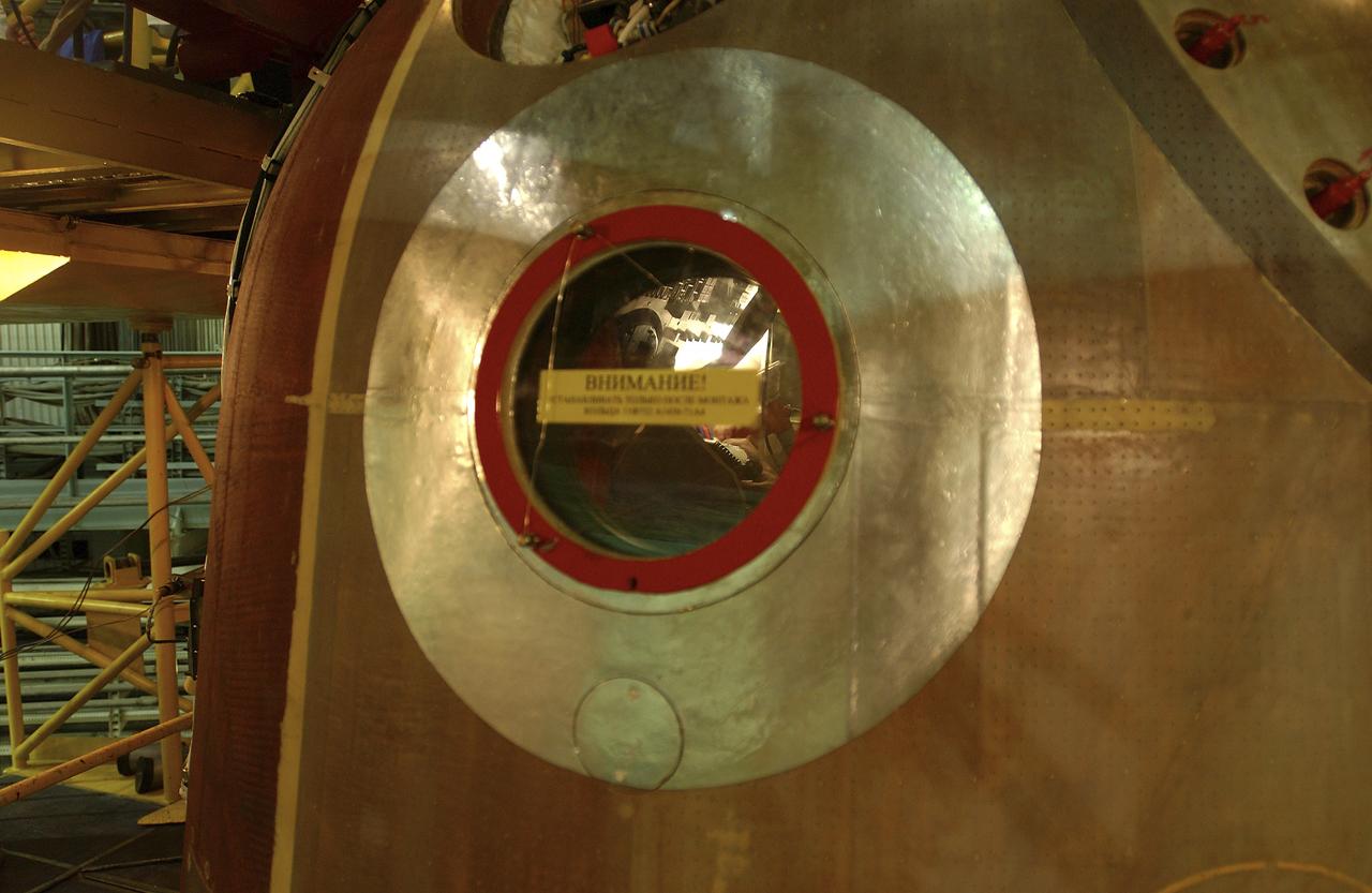The instrument panel of the Soyuz is barely visible through the small window in this viww taken while the crew is inside the capsule for the fit check, Friday, Oct. 5, 2004, at the Baikonur Cosmodrome in Kazakhstan. Photo Credit: (NASA/Bill Ingalls)