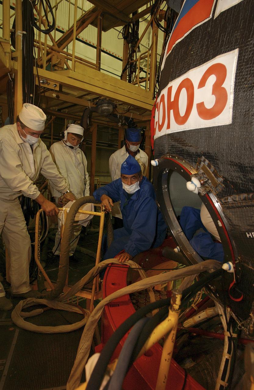 Technicians and engineers wait outside the Soyuz capsule for the crew of Expedition 10 to emerge after a dress rehearsal of launch day activities, Friday, Oct. 5, 2004, at the Baikonur Cosmodrome in Kazakhstan. Photo Credit: (NASA/Bill Ingalls)