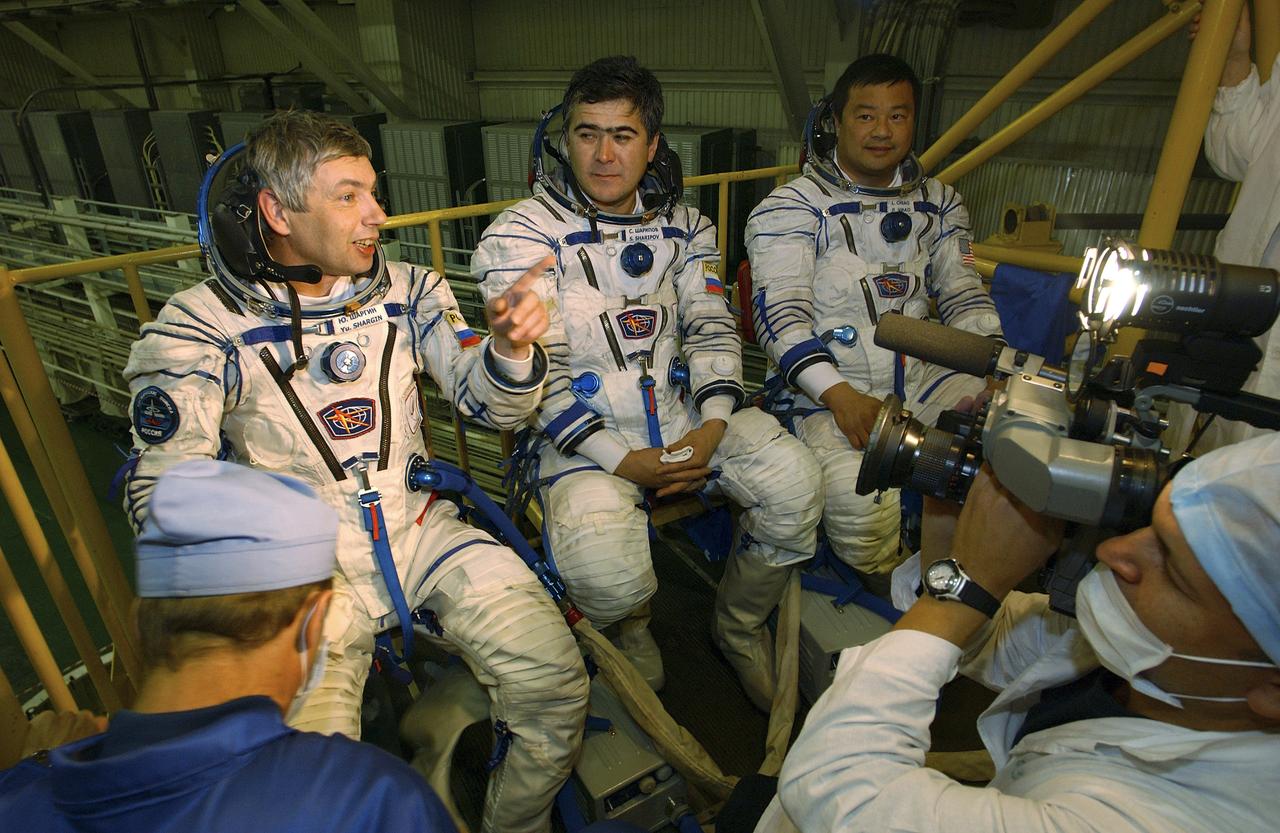 Expedition 10 Commander and NASA Science Officer Leroy Chiao, right, Flight Engineer and Soyuz Commander Salizhan Sharipov and Russian Space Forces cosmonaut Yuri Shargin, left, donned their launch and entry suits and climbed aboard their Soyuz TMA-5 spacecraft Friday, October 5, 2004, at the Baikonur Cosmodrome in Kazakhstan for a dress rehearsal of launch day activities leading to their liftoff October 14 to the International Space Station. Chiao and Sharipov, the first crew of all-Asian extraction, will spend six months on the Station.  Shargin will return to Earth October 24 with the Stations' current residents, Expedition 9 Commander Gennady Padalka and NASA Flight Engineer and Science Officer Mike Fincke.  Photo Credit: (NASA/Bill Ingalls) 