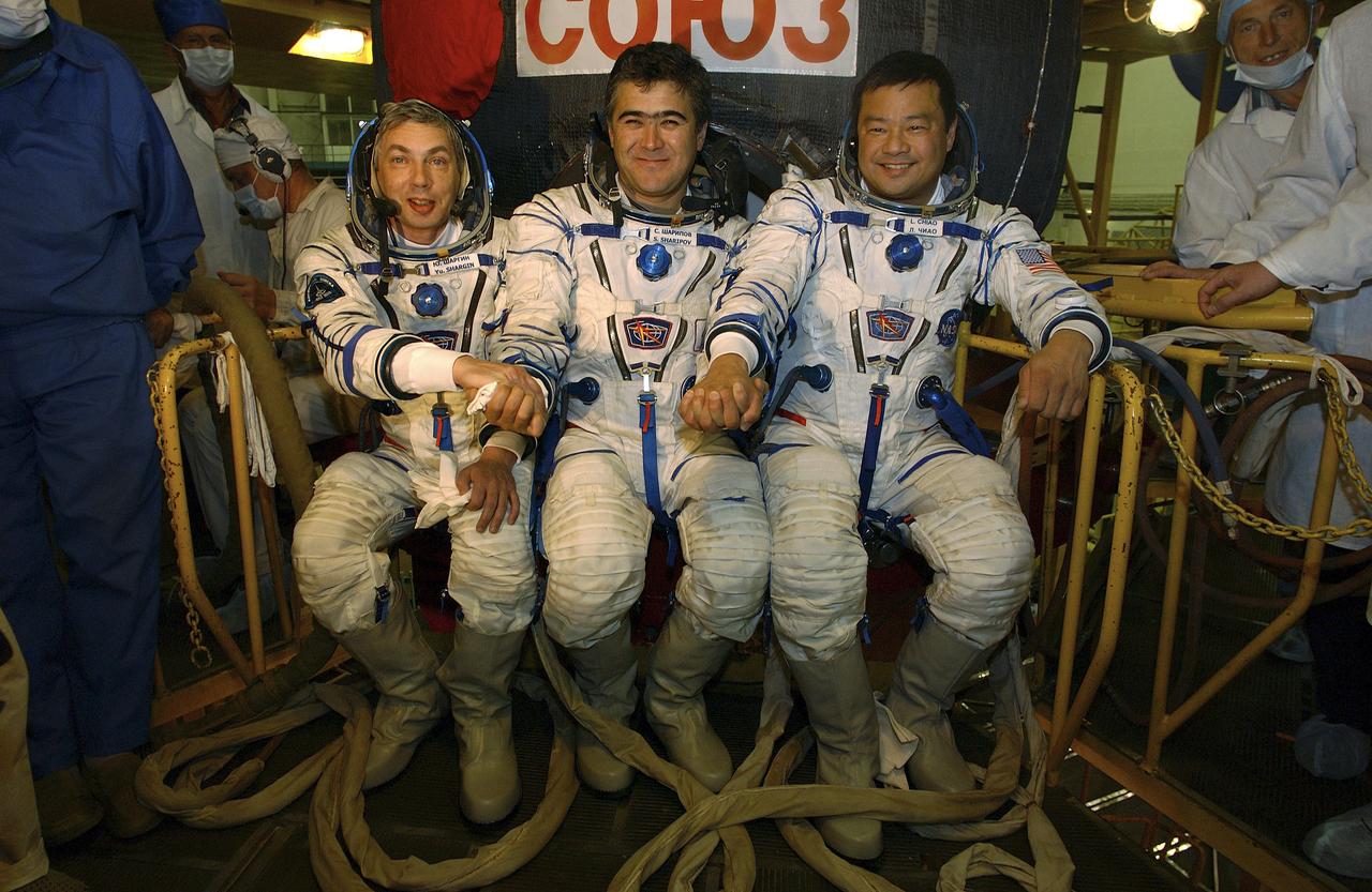 Expedition 10 Commander and NASA Science Officer Leroy Chiao, right, Flight Engineer and Soyuz Commander Salizhan Sharipov and Russian Space Forces cosmonaut Yuri Shargin, left, donned their launch and entry suits and climbed aboard their Soyuz TMA-5 spacecraft Friday, October 5, 2004, at the Baikonur Cosmodrome in Kazakhstan for a dress rehearsal of launch day activities leading to their liftoff October 14 to the International Space Station. Chiao and Sharipov, the first crew of all-Asian extraction, will spend six months on the Station.  Shargin will return to Earth October 24 with the Stations' current residents, Expedition 9 Commander Gennady Padalka and NASA Flight Engineer and Science Officer Mike Fincke.  Photo Credit: (NASA/Bill Ingalls) 