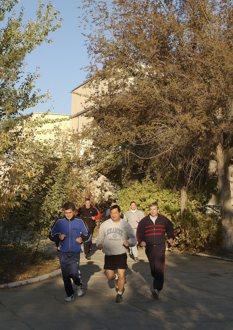 Expedition 10 Flight Engineer and Soyuz Commander Salizhan Sharipov, foregroung left, Commander and NASA Science Officer Leroy Chiao, Russian Space Forces cosmonaut Yuri Shargin, backup Soyuz Commander Valery Tokarev and backup Expedition Commander Bill McArthur, background right, go for an early morning jog on the grounds of the Cosmonaut Hotel, Baikonur, Kazakhstan, Friday, Oct. 8, 2004. Chiao, Sharipov and Shargin are scheduled to launch October 14 on their Soyuz TMA-5 spacecraft to the International Space Station. Photo Credit: (NASA/Bill Ingalls)