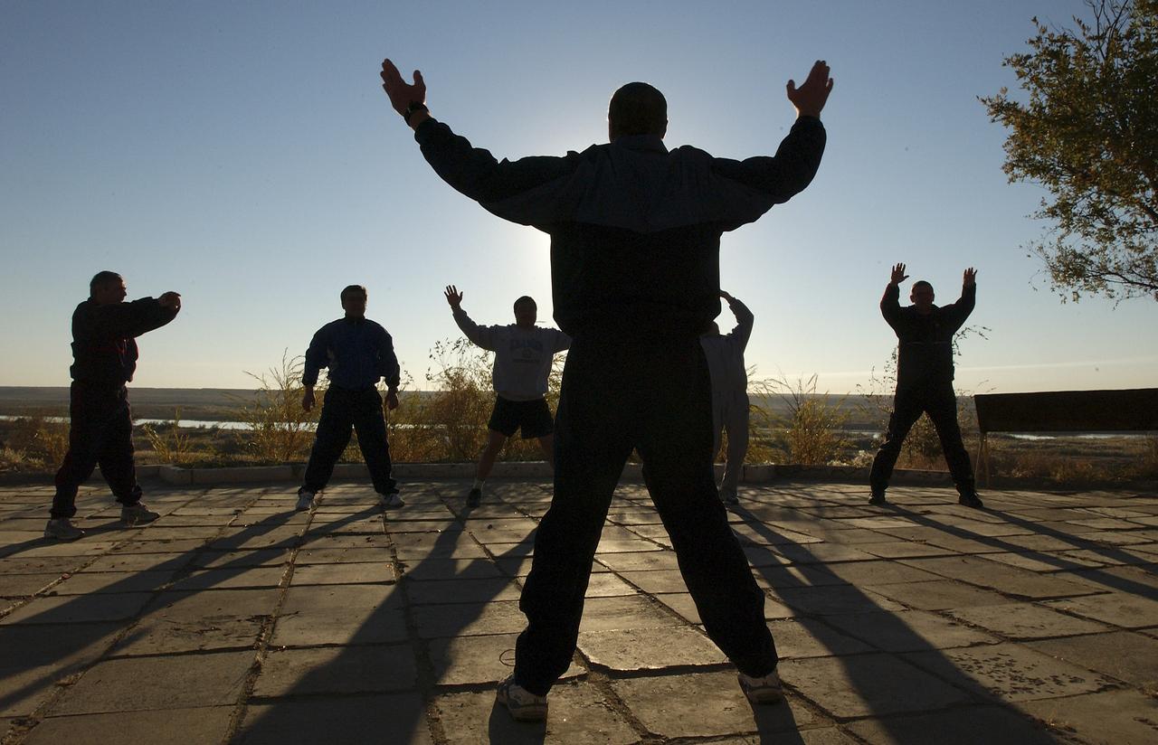 Russian Space Forces cosmonaut Yuri Shargin, far left, Expedition 10 Flight Engineer and Soyuz Commander Salizhan Sharipov, Commander and NASA Science Officer Leroy Chiao, backup Soyuz Commander Valery Tokarev and backup Expedition Commander Bill McArthur, far right, are lead by an instructor for early morning exercises on the grounds of the Cosmonaut Hotel, Baikonur, Kazakhstan, Friday, October 8, 2004. Chiao, Sharipov and Shargin are scheduled to launch October 14 on their Soyuz TMA-5 spacecraft to the International Space Station. Photo Credit: (NASA/Bill Ingalls)