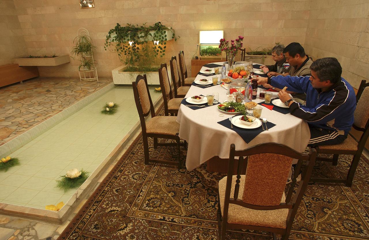 Flight Engineer and Soyuz Commander Salizhan Sharipov, foreground right, Expedition 10 Commander Leroy Chiao and Russian Space Forces cosmonaut Yuri Shargin, background right, enjoy lunch at their crew quarters in Baikonur, Kazakhstan, Friday, October 8, 2004, as they prepare for liftoff to the International Space Station October 14.  Photo Credit: (NASA/Bill Ingalls)