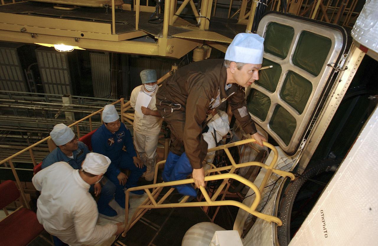 Russian Space Forces cosmonaut Yuri Shargin, right, Expedition 10 Commander and NASA Science Officer Leroy Chiao and Flight Engineer and Soyuz Commander Salizhan Sharipov, lower left, conducted a final inspection of their Soyuz TMA-5 spacecraft, Saturday, October 9, 2004, at the Baikonur Cosmodrome in Kazakhstan in preparation for their launch October 14 to the International Space Station. The Soyuz vehicle will be mated to its booster rocket October 11 in preparation for its rollout to the Central Asian launch pad October 12. Photo Credit: (NASA/Bill Ingalls)