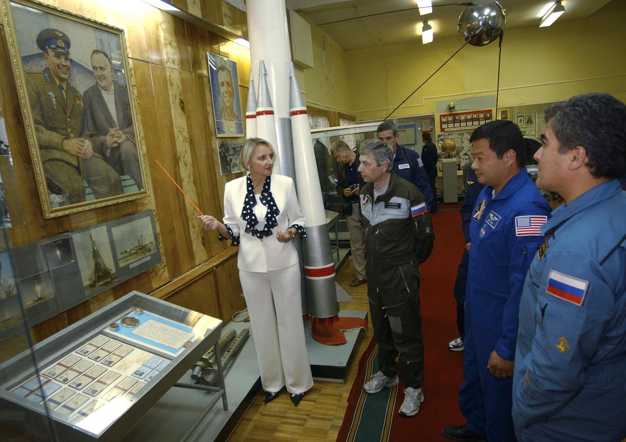 Flight Engineer and Soyuz Commander Salizhan Sharipov, right, Expedition 10 Commander and NASA Science Officer Leroy Chiao and Russian Space Forces cosmonaut Yuri Shargin, left, toured a museum bearing the name of historic Russian rocket designer Sergei Korolev, Saturday, October 9, 2004, at the Baikonur Cosmodrome in Kazakhstan prior to their liftoff to the International Space Station October 14.  The traditional visit included the signing of their names in commemorative books and a wall at the museum, and touring the cottages nearby where Korolev and Yuri Gagarin slept on the eve of Gagarin's launch April 12, 1961 to become the first human in space.  The tour guide points out a piece of art made entirely of painted grains of rice depicting Yuri Gargarin and Korolev.  Photo Credit: (NASA/Bill Ingalls)