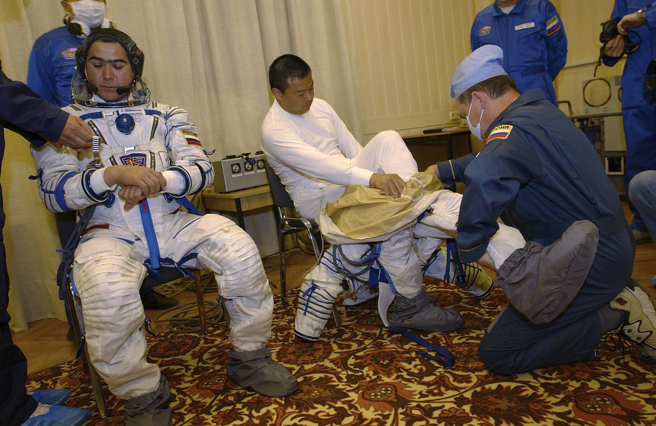 Expedition 10 Soyuz Commander Salizhan Sharipov, left and Expedition 10 Commander Leroy Chiao don their flight suits prior to their launch on board the Soyuz TMA-5 spacecraft to the International Space Station, Thursday, Oct. 14, in Baikonur, Kazakhstan.  The crew will dock to the Station on October 16, and Chiao and Sharipov will replace the current Station crew members, Gennady Padalka and Mike Fincke, who will return to Earth October 24 with Shargin.  Photo Credit: (NASA/Bill Ingalls)