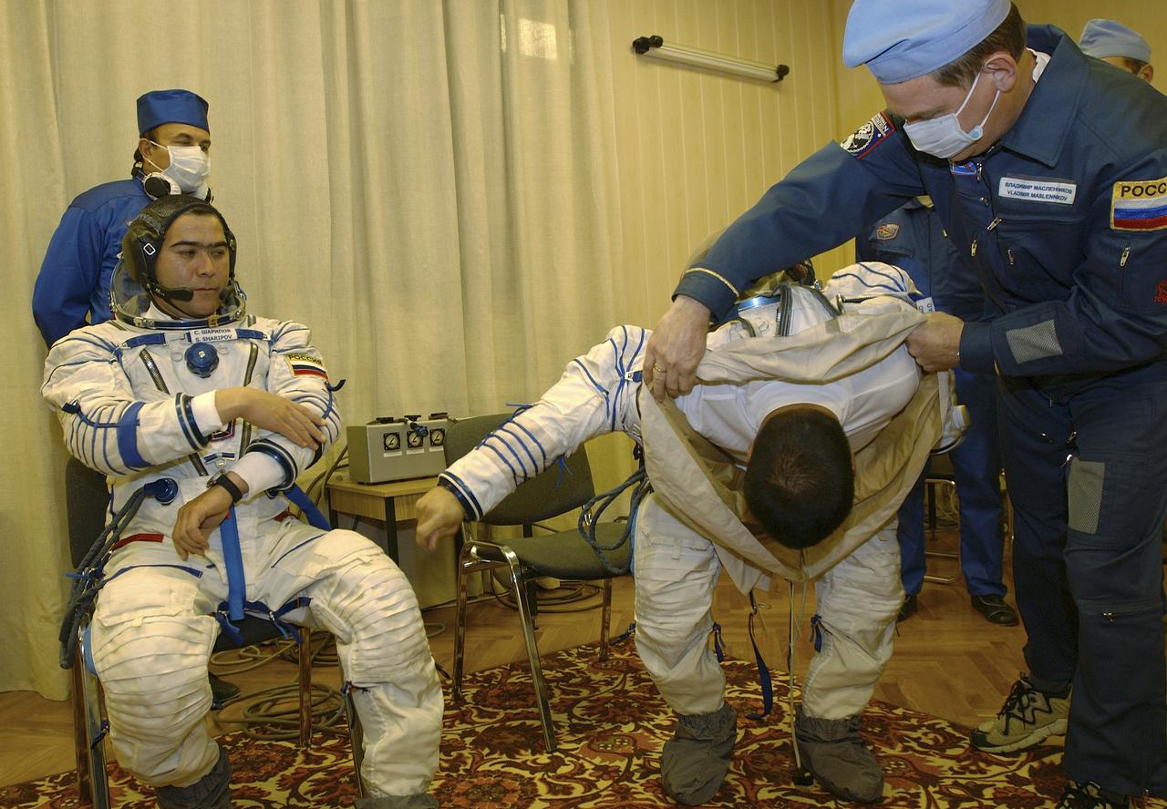 Expedition 10 Soyuz Commander Salizhan Sharipov, left and Expedition 10 Commander Leroy Chiao don their flight suits prior to their launch on board the Soyuz TMA-5 spacecraft to the International Space Station, Thursday, Oct. 14, in Baikonur, Kazakhstan. The crew will dock to the Station on October 16, and Chiao and Sharipov will replace the current Station crew members, Gennady Padalka and Mike Fincke, who will return to Earth October 24 with Shargin. Photo Credit: (NASA/Bill Ingalls)