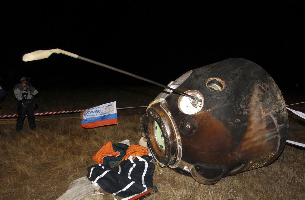 The Soyuz capsule lays on its side after landing approximately 85 kilometers northeast of Arkalyk in northern Kazakhstan with the crew of Expedition 9 and Russian Space Forces cosmonaut Yuri Shargin, Sunday, October 24, 2004.  Photo Credit: (NASA/Bill Ingalls)
