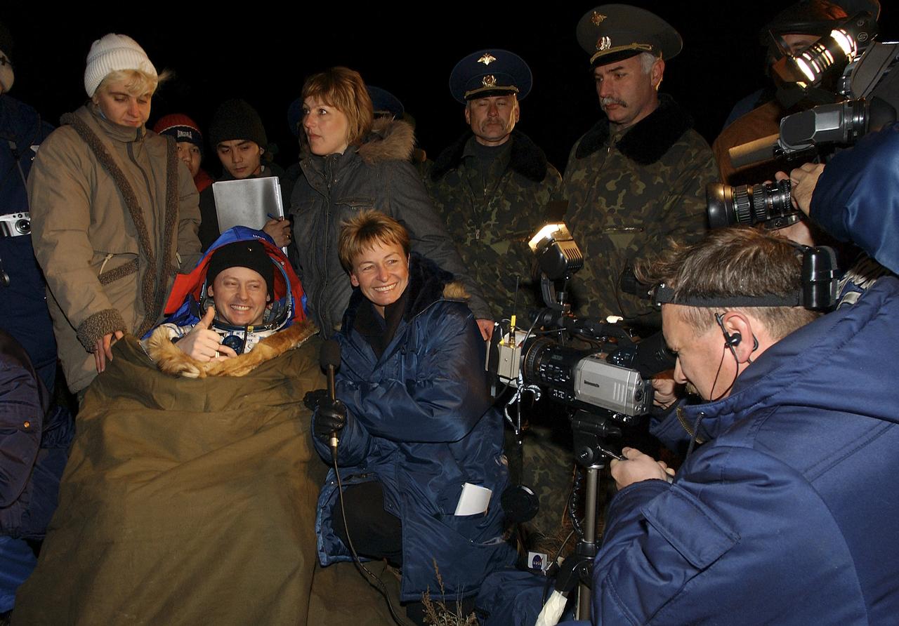 Expedition 9 Flight Engineer Michael Fincke is interviewed by former Expedition 5 Flight Engineer Peggy Whitson for the video phone after the successful landing in the Soyuz spacecraft with fellow crew members Expedition 9 Commander Gennady Padalka and Russian Space Forces cosmonaut Yuri Shargin. The crew landed in their Soyuz capsule approximately 85 kilometers northeast of Arkalyk in northern Kazakhstan, Sunday, October 24, 2004.  Photo Credit: (NASA/Bill Ingalls)