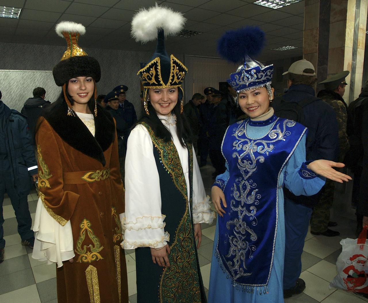 Women dressed in traditional Kazak clothing pose for a photo after presenting the returning Expedition 9 and taxi flight crew members with gifts at the airport in Kustanay, Kazakhstan, Sunday, October 24, 2004. Photo Credit: (NASA/Bill Ingalls)