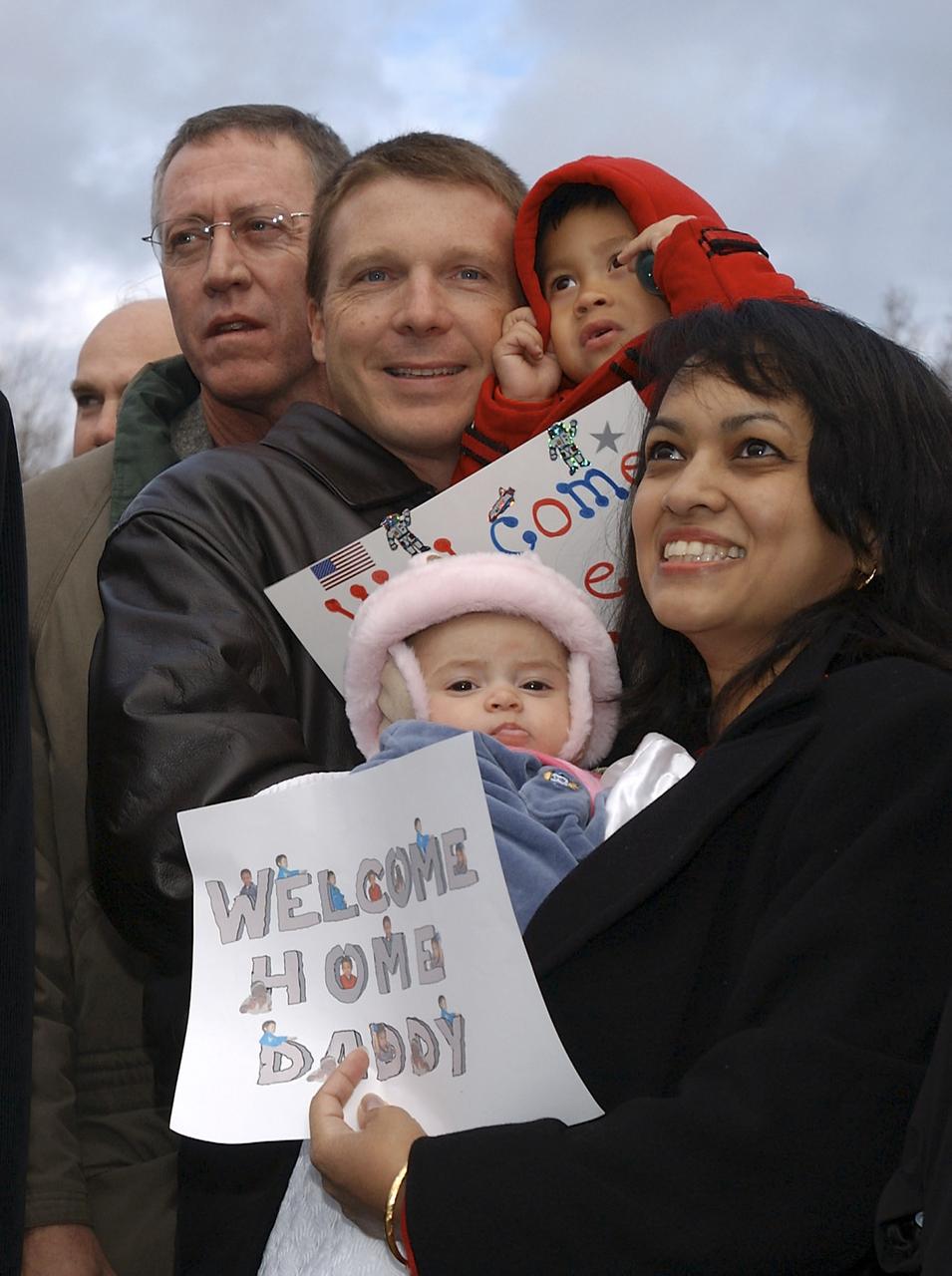 Renita Fincke, right, awaits the arrival of her husband NASA astronaut Michael Fincke, while holding their 4 month-old baby Tarali, Sunday, October 24, 2004, in Star City, Russia. Astronaut Terry Virts, Center helps by holding 2 year-old Chandra Fincke. Photo Credit: (NASA/Bill Ingalls)