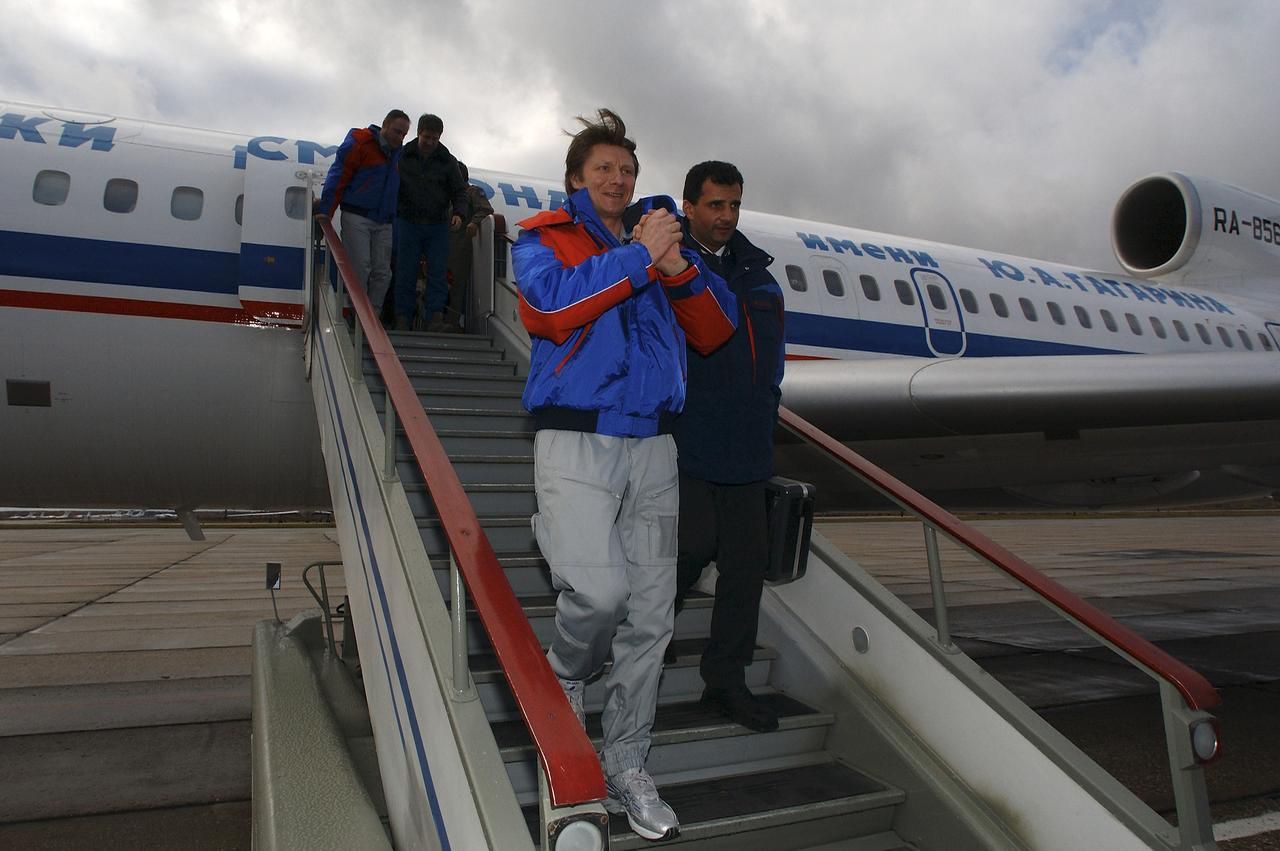 Expedition 9 Commander Gennady Padalka, center, and Expedition 9 Flight Engineer Michael Fincke, background, exit the Gargarin Cosmonaut Training Center's airplane to an awaiting crowd of officials and family members after their flight from Kustanay, Kazakhstan, Sunday, October 24, 2004. Photo Credit: (NASA/Bill Ingalls)