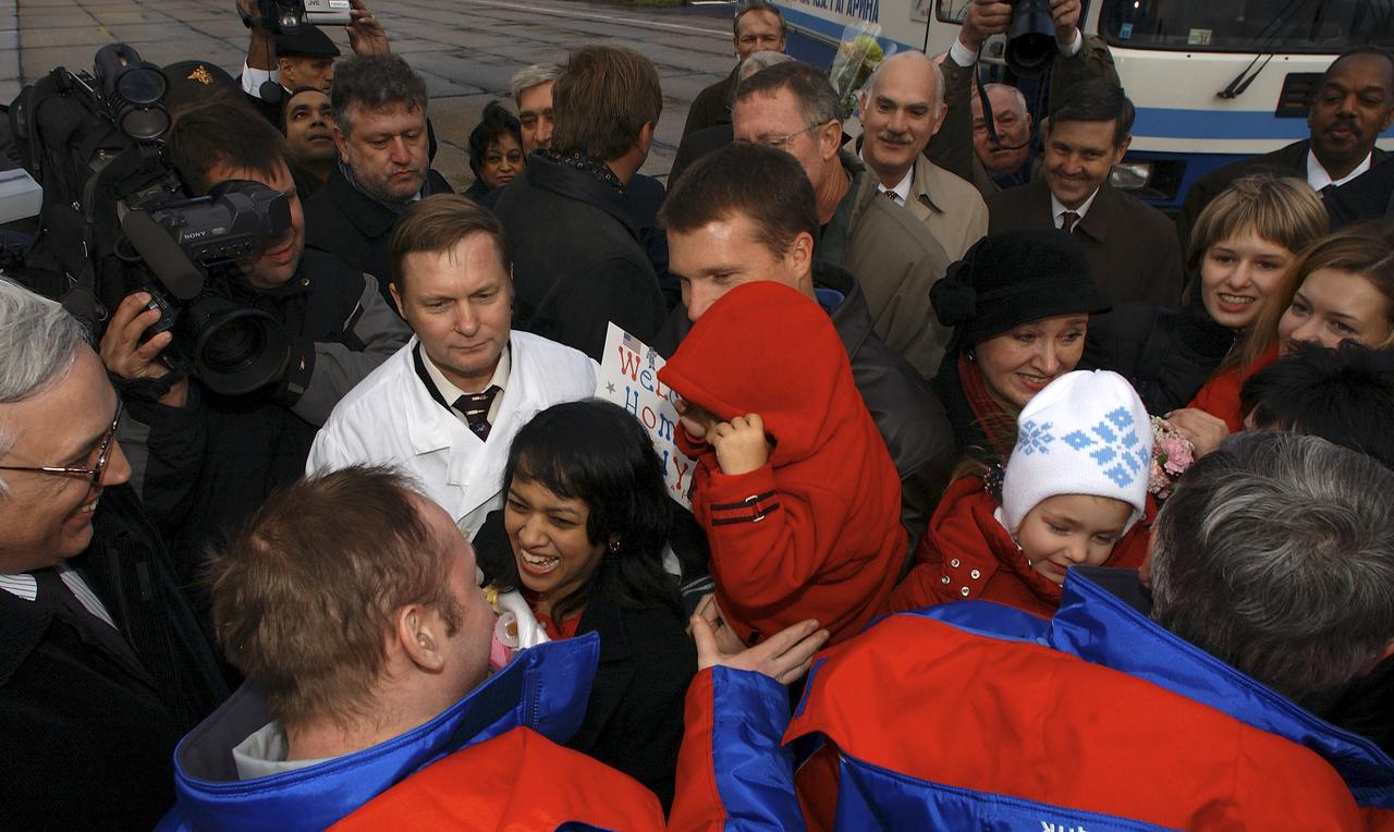 Expedition 9 Flight Engineer Michael Fincke, lower left, greets his wife and children for the first time in six months after exiting the Gargarin Cosmonaut Training Center's airplane in Star City, Russia, Sunday October 24, 2004. Photo Credit: (NASA/Bill Ingalls)