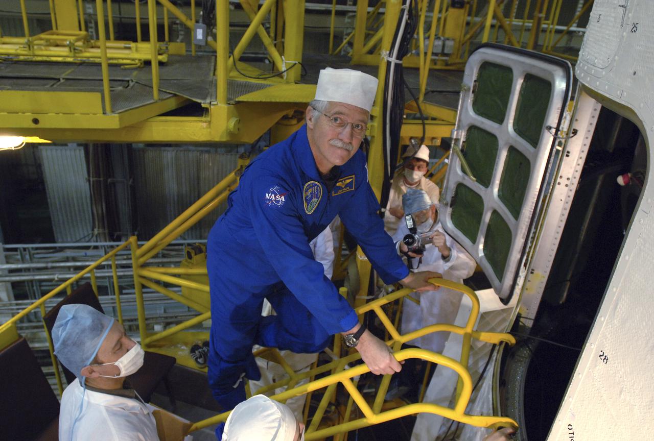 Expedition 11 Flight Engineer John Phillips enters the Soyuz TMA-6 spacecraft at the Baikonur Cosmodrome in Baikonur, Kazakhstan, Sunday, April 10, 2005, during preparations for launch to the International Space Station. Phillips along with Commander Sergei Krikalev and European Space Agency astronaut Roberto Vittori will launch April 15 on the spacecraft to the International Space Station. Krikalev and Phillips will spend six months in space and greet the first Shuttle crew to fly in more than two years when it arrives at the station, while Vittori spends eight days on the station under a commercial contract between ESA and the Russian Federal Space Agency. Photo Credit: (NASA/Bill Ingalls)