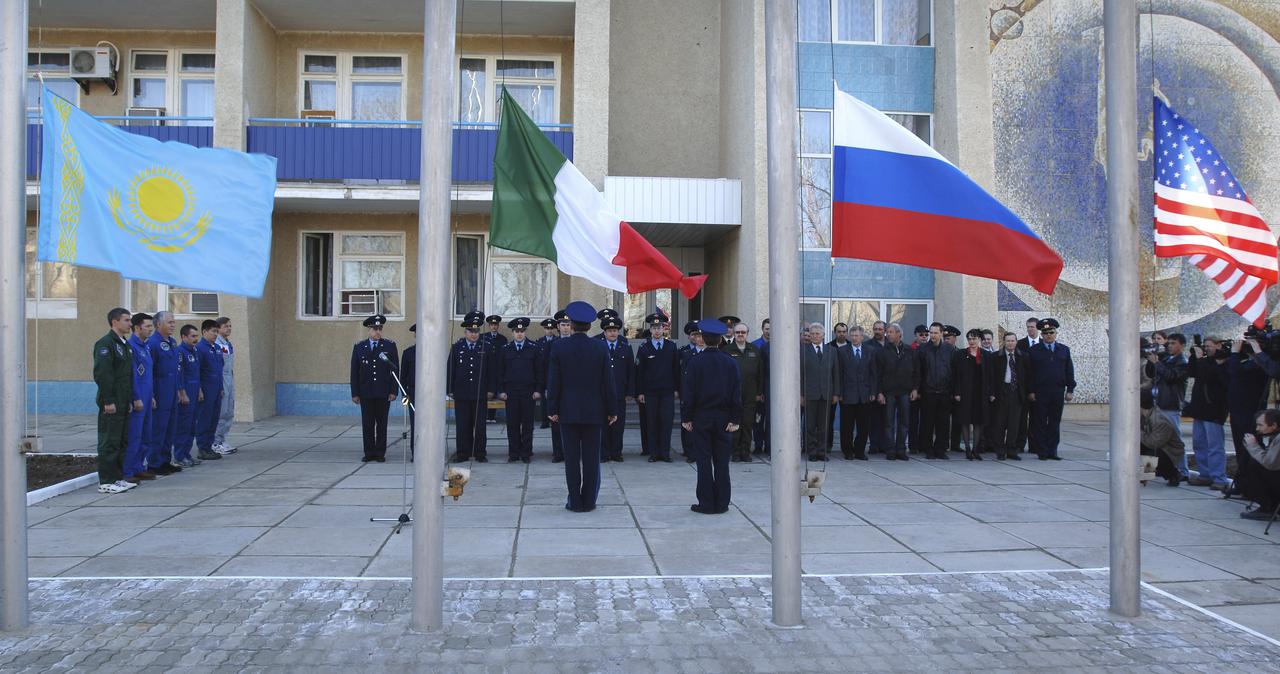Expedition 11 Commander Sergei Krikalev, left, European Space Agency astronaut Roberto Vittori, of Italy, Flight Engineer John Phillips, third from left, along with their backups, Russian Commander Mikhail Tyurin, American Dan Tani and Robert Thirsk, of Canada, far right, participate in the traditional raising of their countries’ flags outside their crew quarters in Baikonur, Kazakhstan on Monday, April 11, 2005, during preparations for the  April 15 launch on a Soyuz TMA-6 spacecraft to the International Space Station. Krikalev and Phillips will spend six months in space and greet the first Shuttle crew to fly in more than two years when it arrives at the station, while Vittori spends eight days on the station under a commercial contract between ESA and the Russian Federal Space Agency. Photo Credit: (NASA/Bill Ingalls)